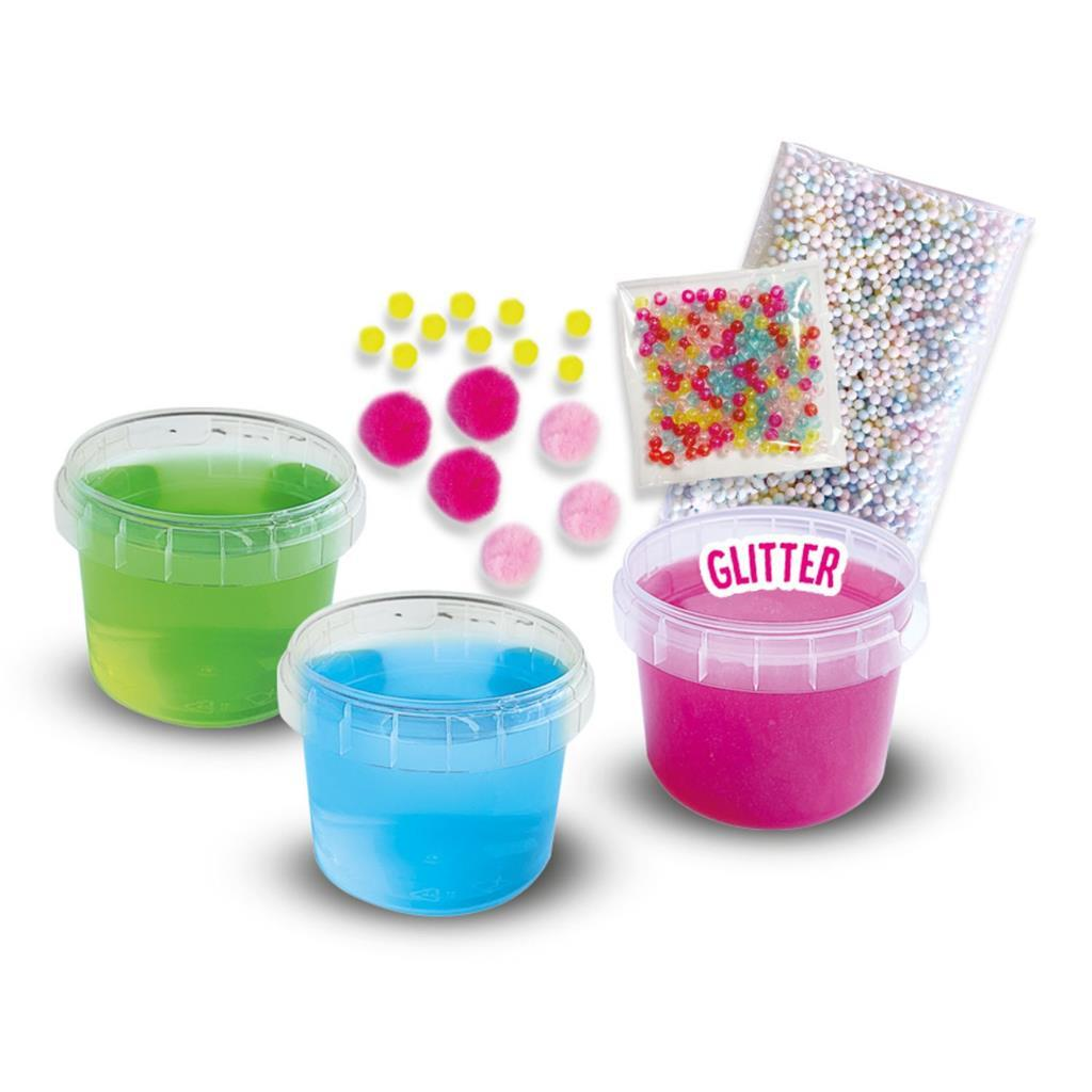 Drei Becher mit farbiger Masse, Pompons und Glitzer für Bastelarbeiten.
