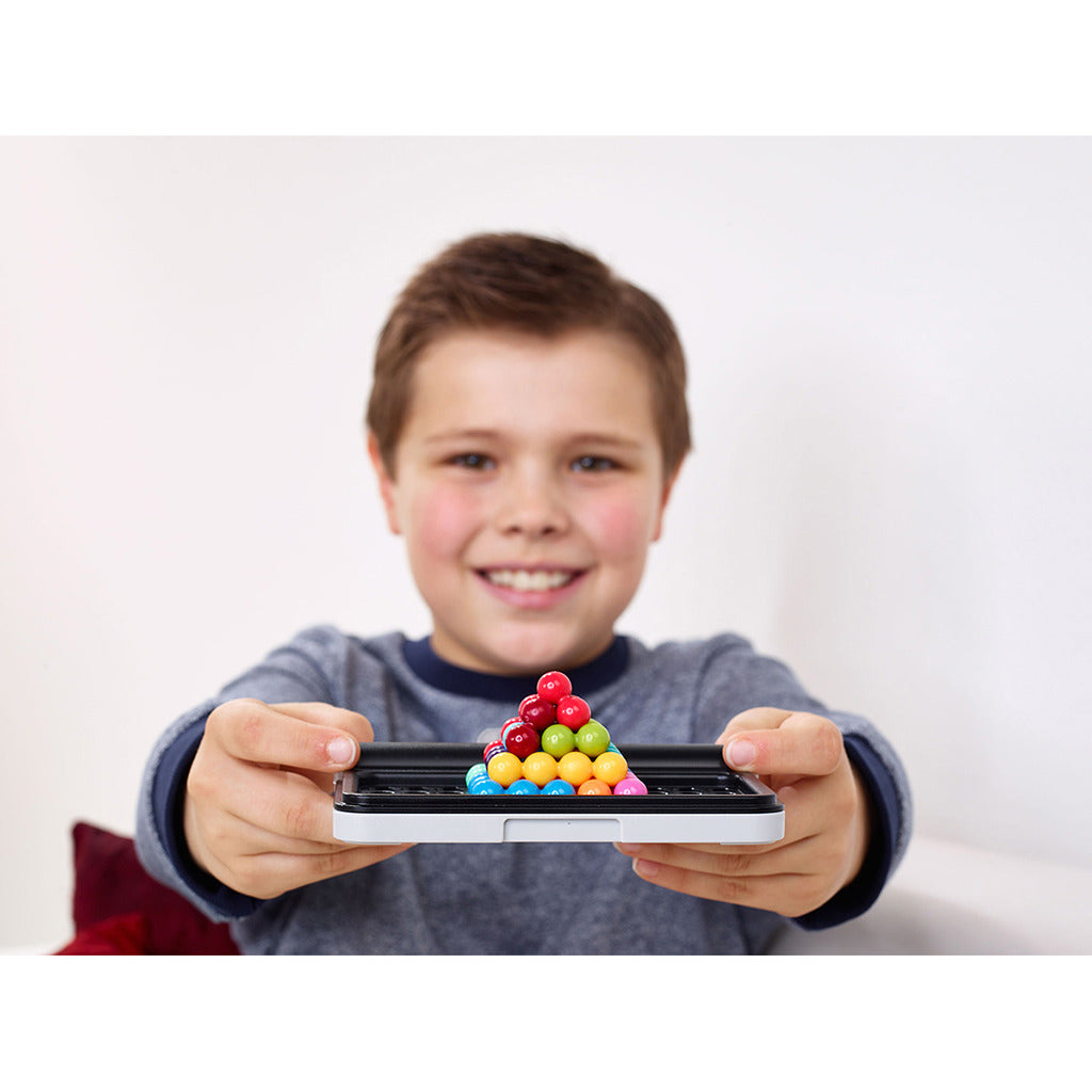 Un ragazzo tiene un gioco con palline colorate disposte a piramide.