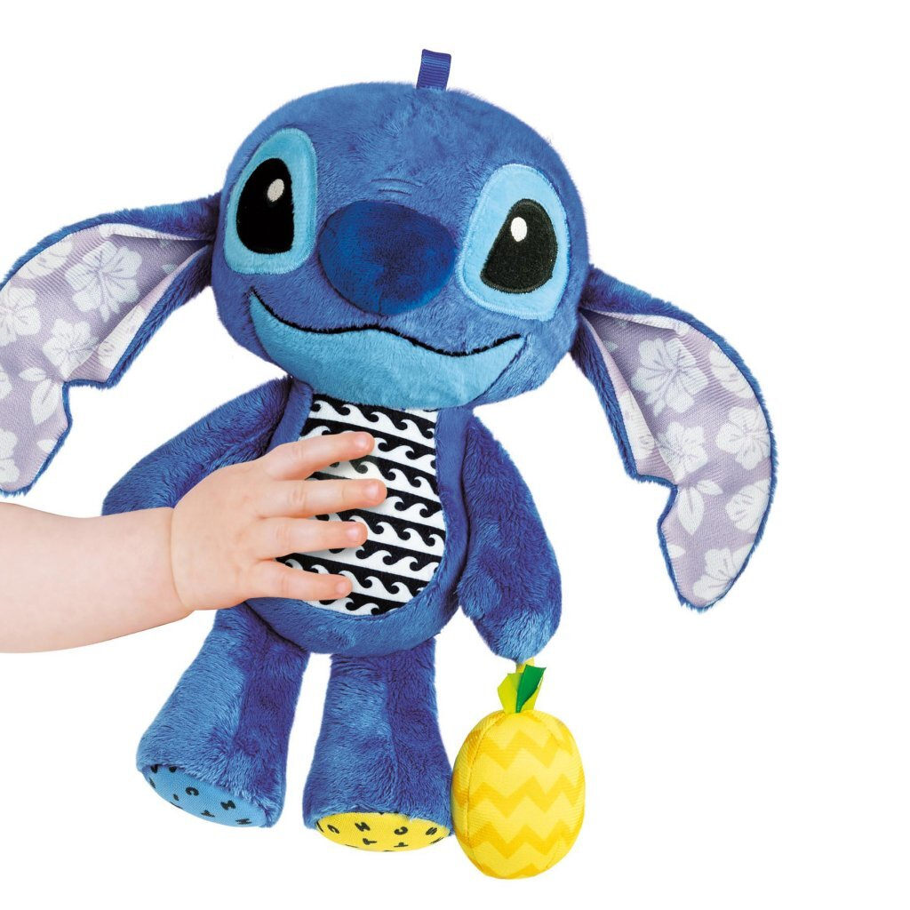 Un peluche azul de Stitch sostenido por una mano pequeña, con una piña amarilla en su pierna.