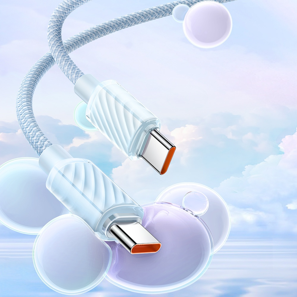Yumuşak mavi gökyüzüne karşı mavi örgülü kablolu iki beyaz USB-C kablosu.