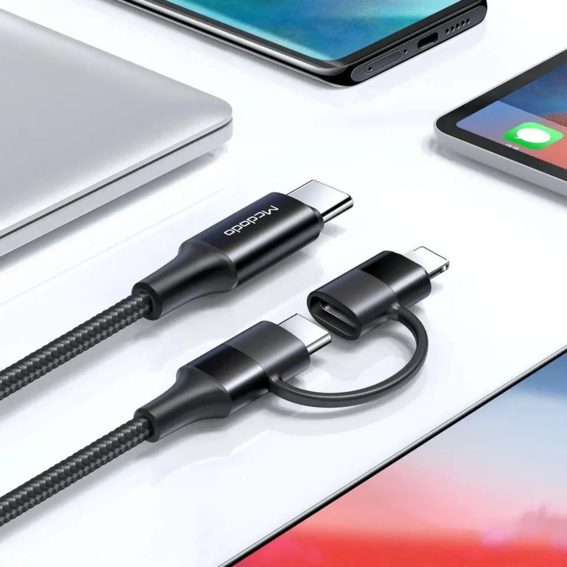 İki konektörlü siyah bir USB-C kablosu, dizüstü bilgisayarlar ve akıllı telefonlar yanında.