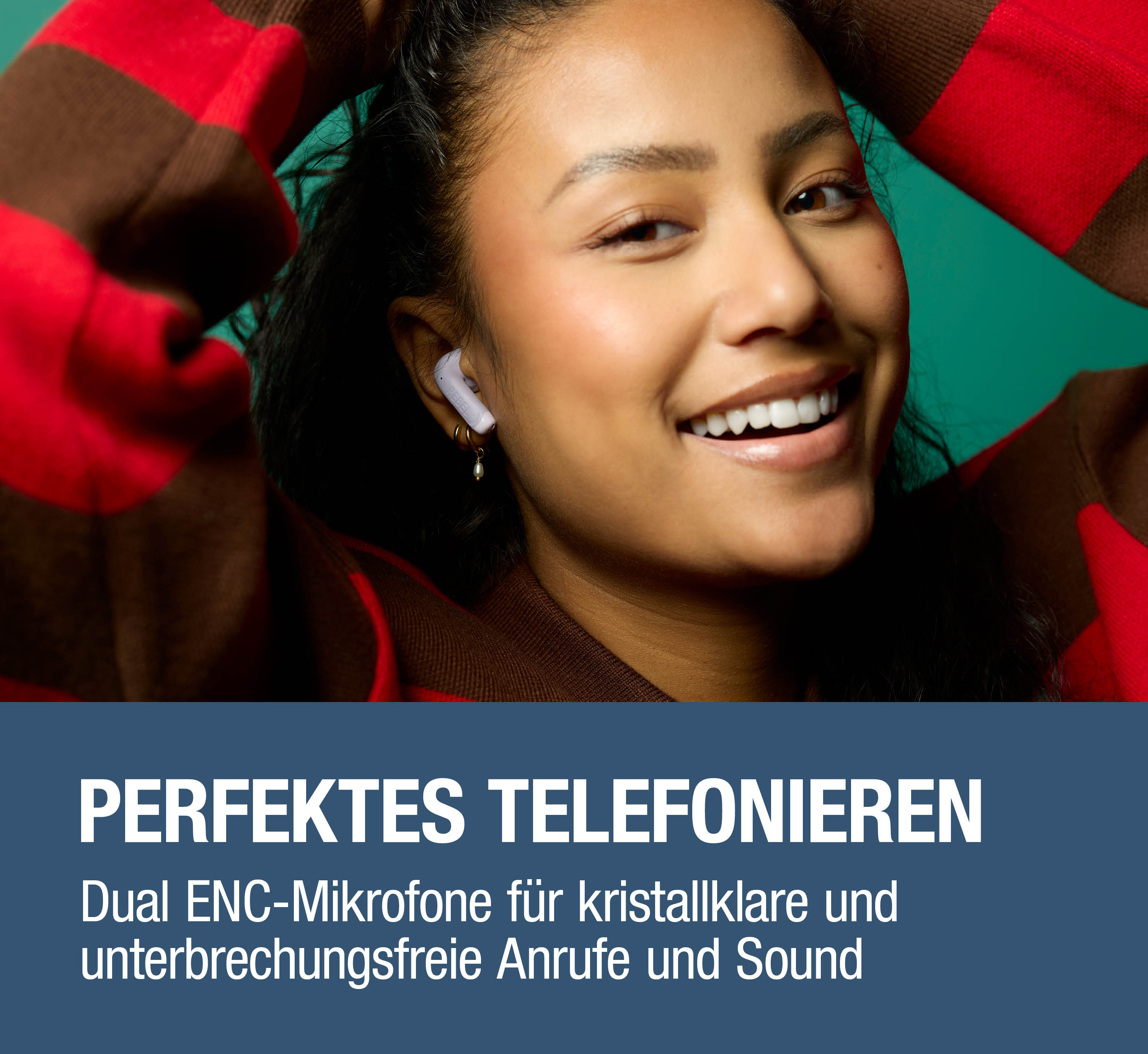 Eine Frau mit Kopfhörern und einem gestreiften Pullover lächelt.