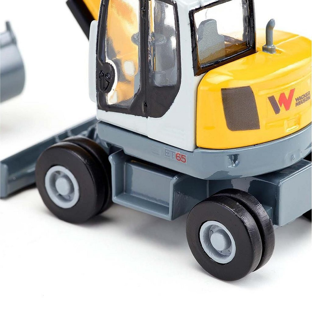 Gelber und grauer Bagger mit schwarzen Rädern, Nahaufnahme.