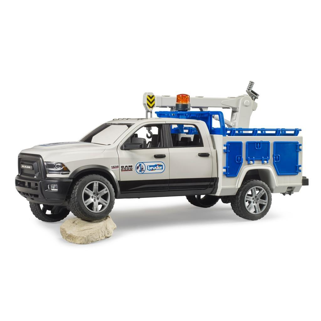 Weißer Ram 2500 Pickup mit Werkzeugkastenaufbau und Kran, auf einem Stein.