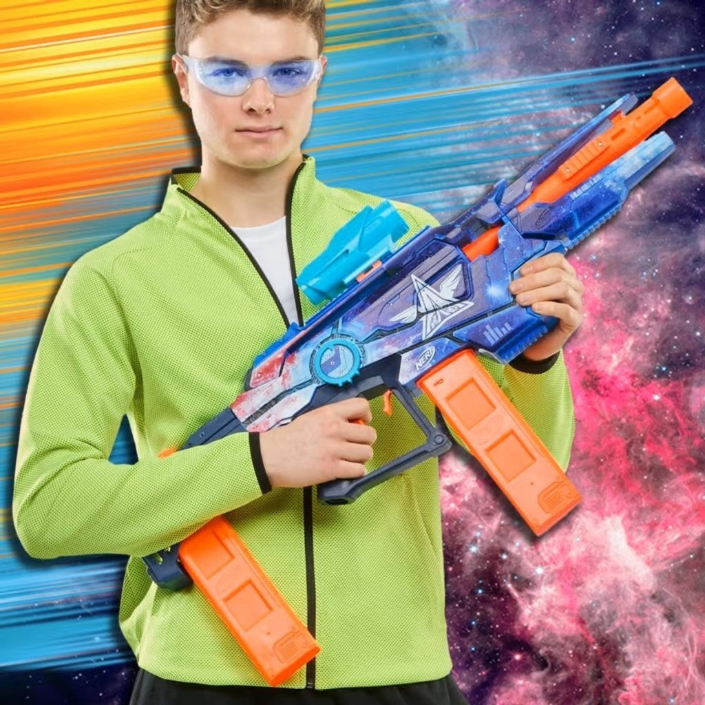Un chico con gafas de seguridad azules sostiene un rifle Nerf azul y naranja con fondo cósmico.