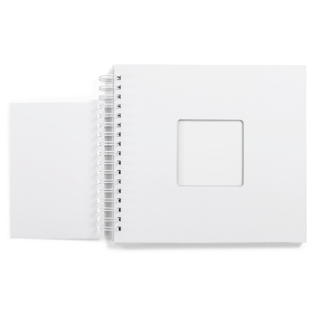Un carnet blanc ouvert avec une fenêtre carrée sur la couverture.
