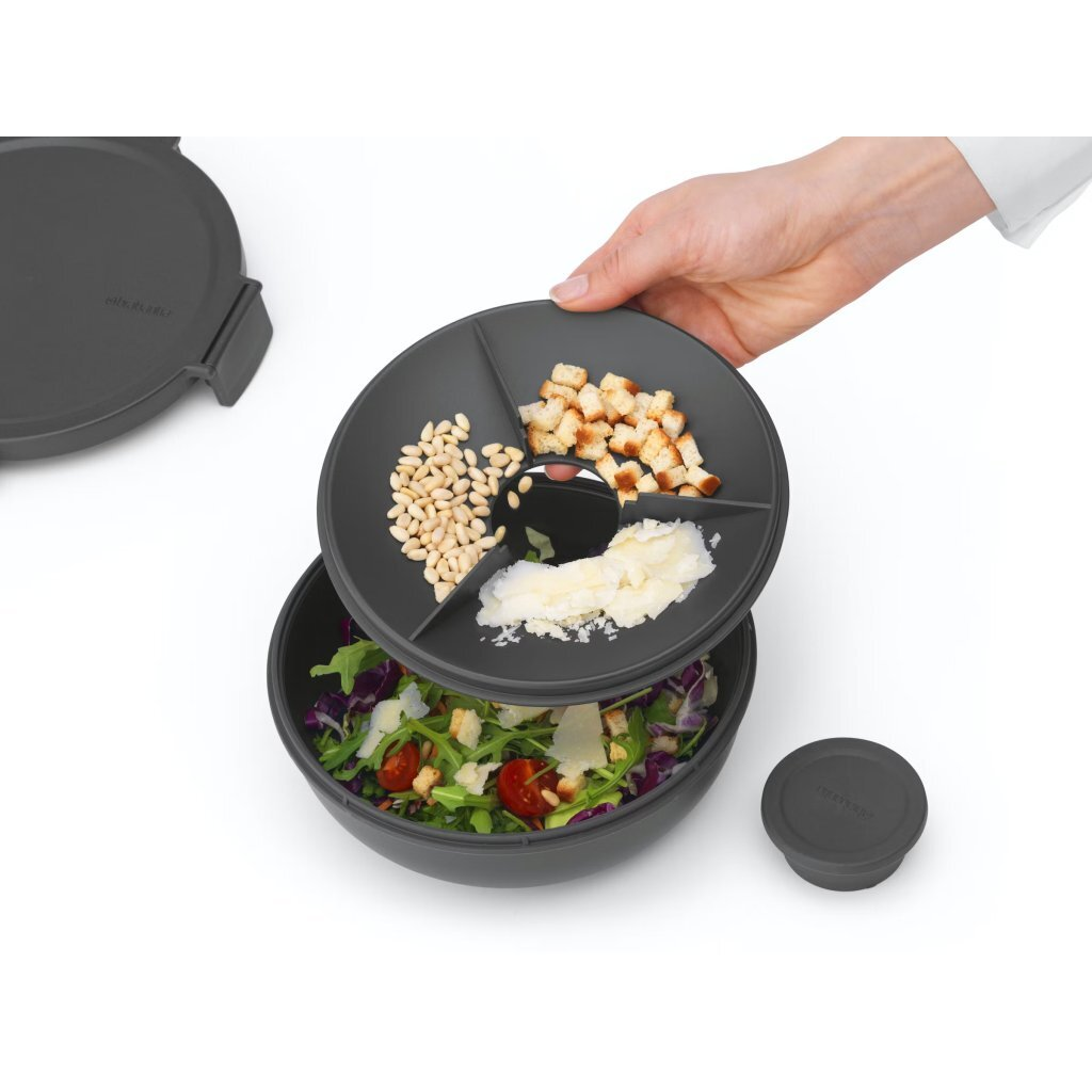 Contenitore per insalata grigio con tre scomparti per condimenti: pinoli, crostini, parmigiano.