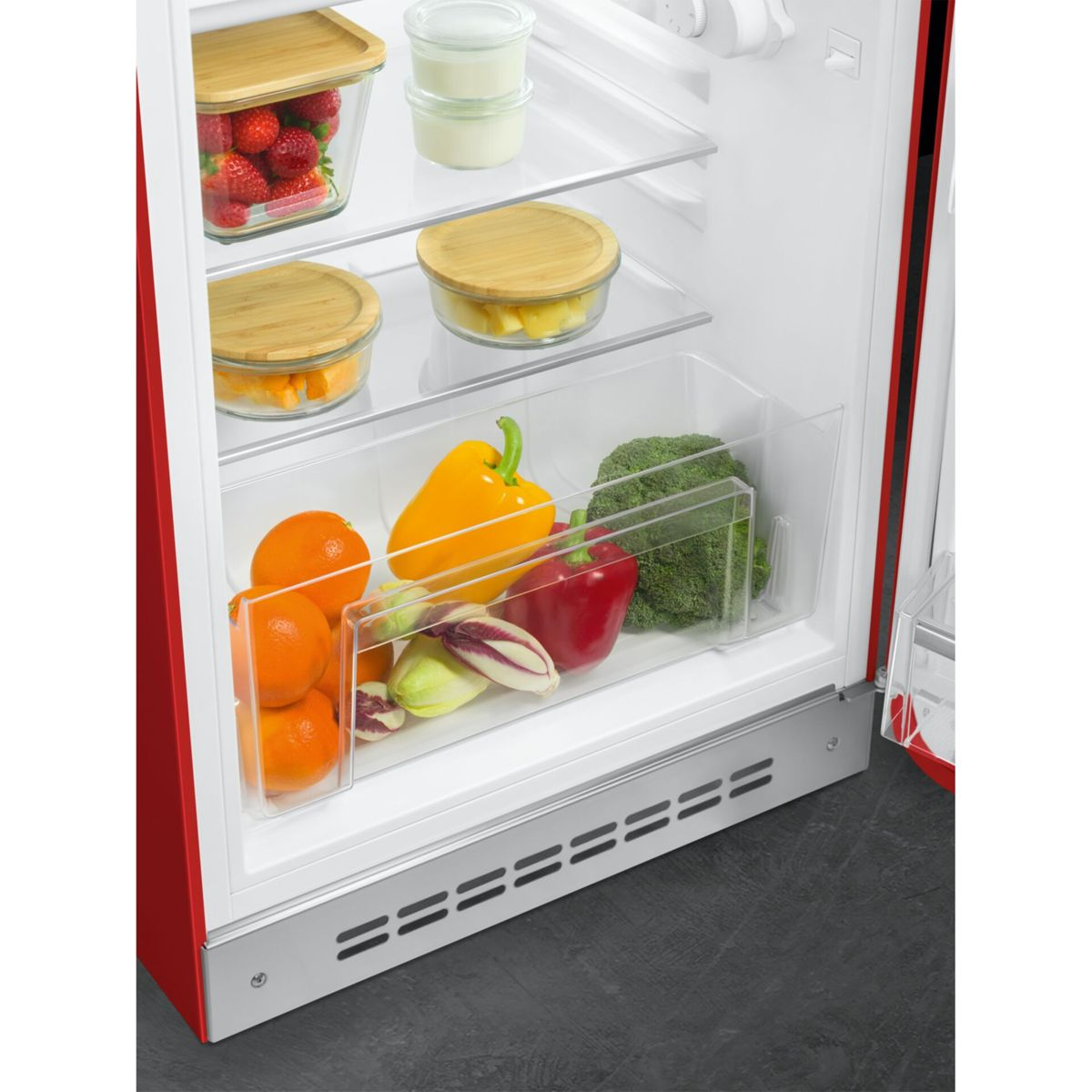 Refrigerador rojo con compartimento abierto con frutas y verduras.