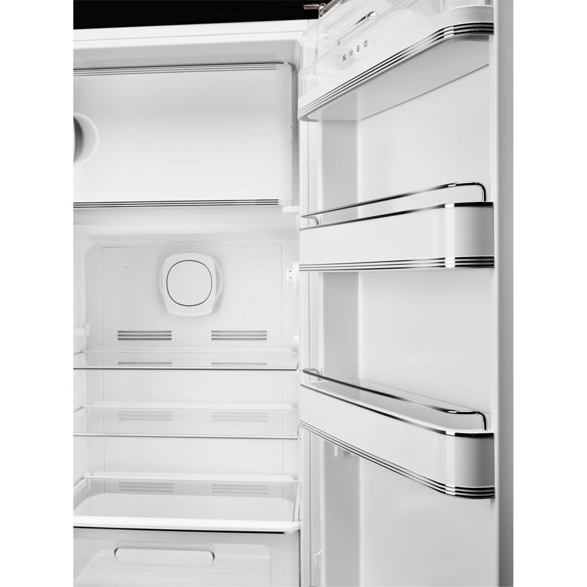 Interior de refrigerador blanco abierto con estantes y estantes de puerta. Logotipo Smeg visible.