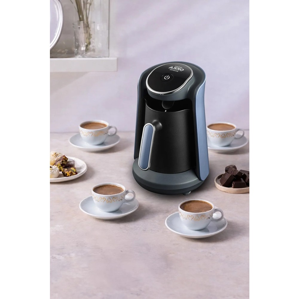 Macchina da caffè con quattro tazze di caffè, pasticcini e cioccolato.