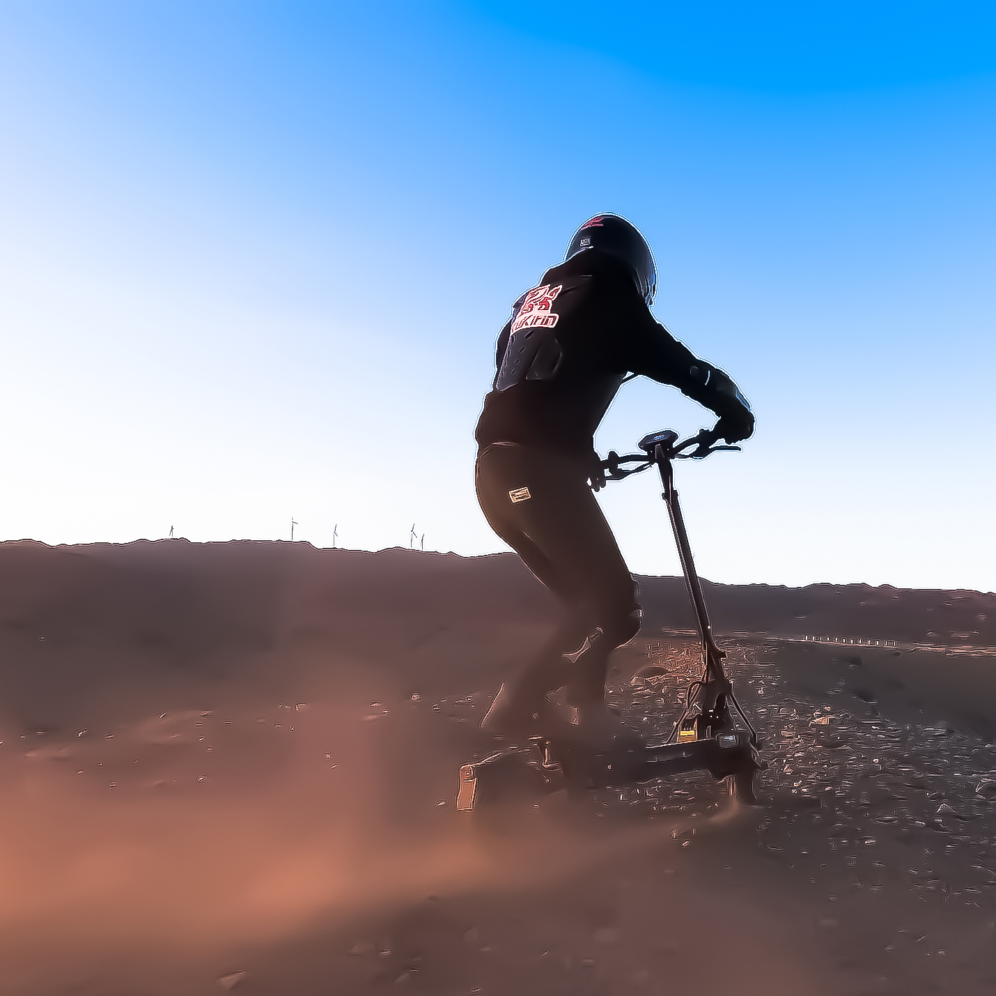 Un pilota su uno scooter elettrico guida attraverso un terreno polveroso sotto un cielo blu.