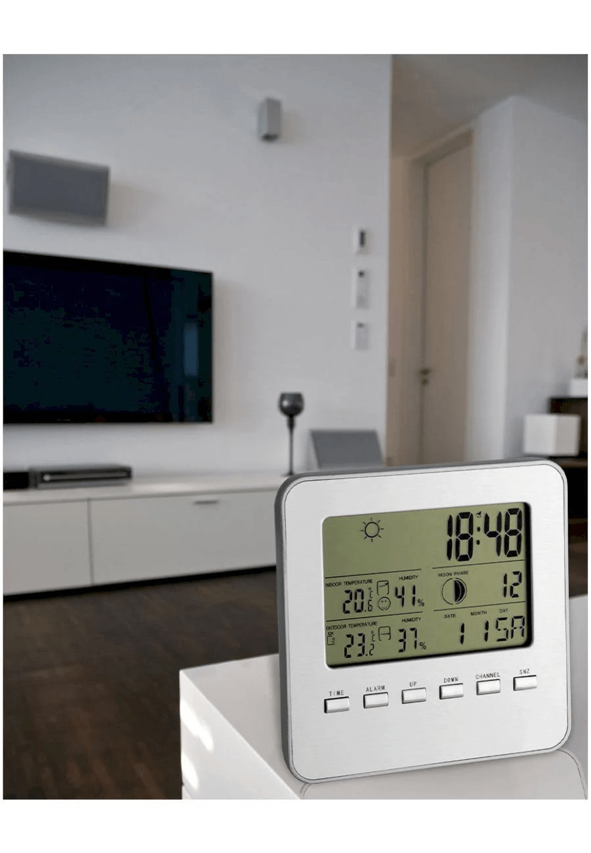 Ein digitales Wetterstation zeigt Zeit, Innen-/Außentemperatur, Luftfeuchtigkeit.