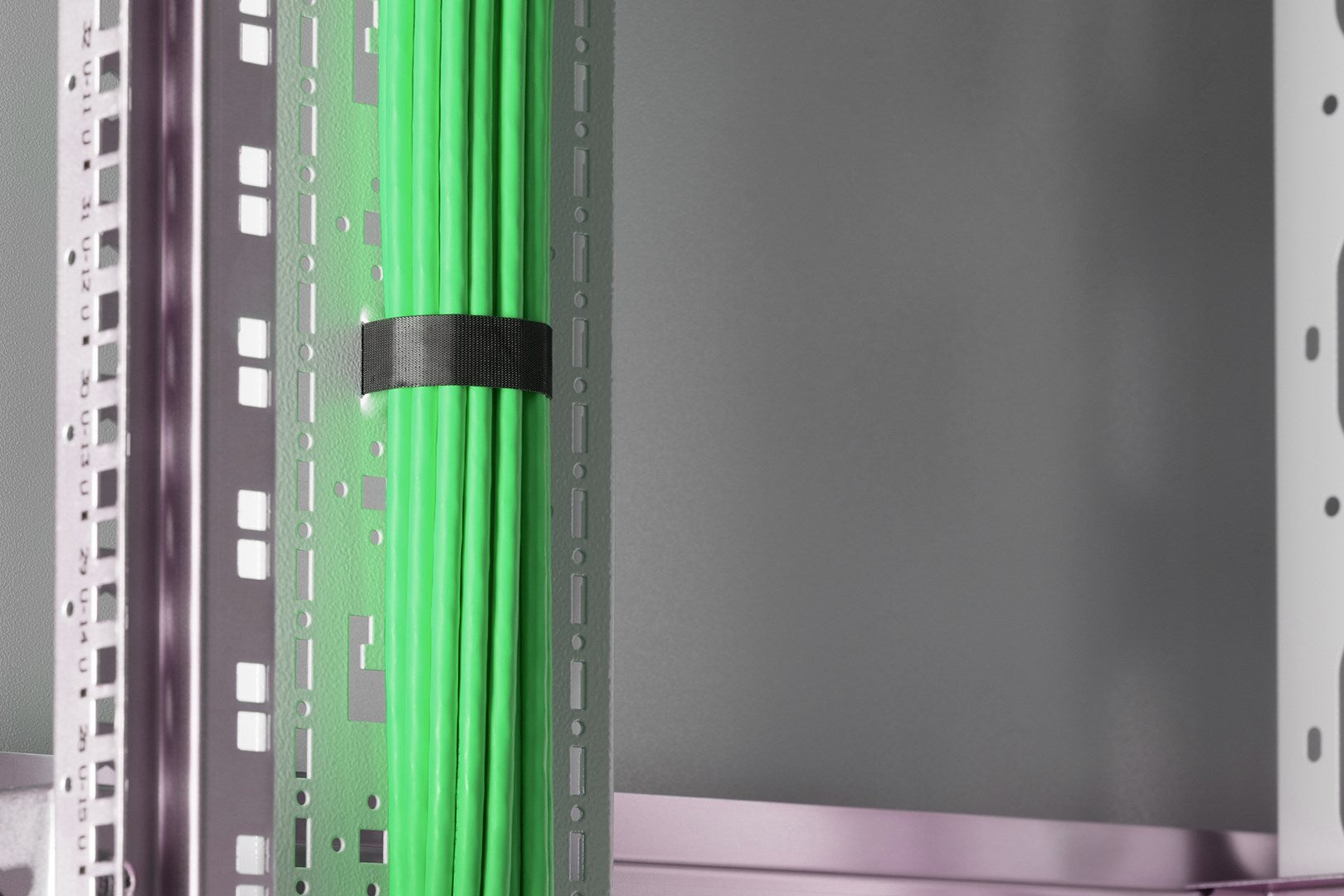 Grüne Kabel sind mit einem schwarzen Band in einem Rack gebündelt.