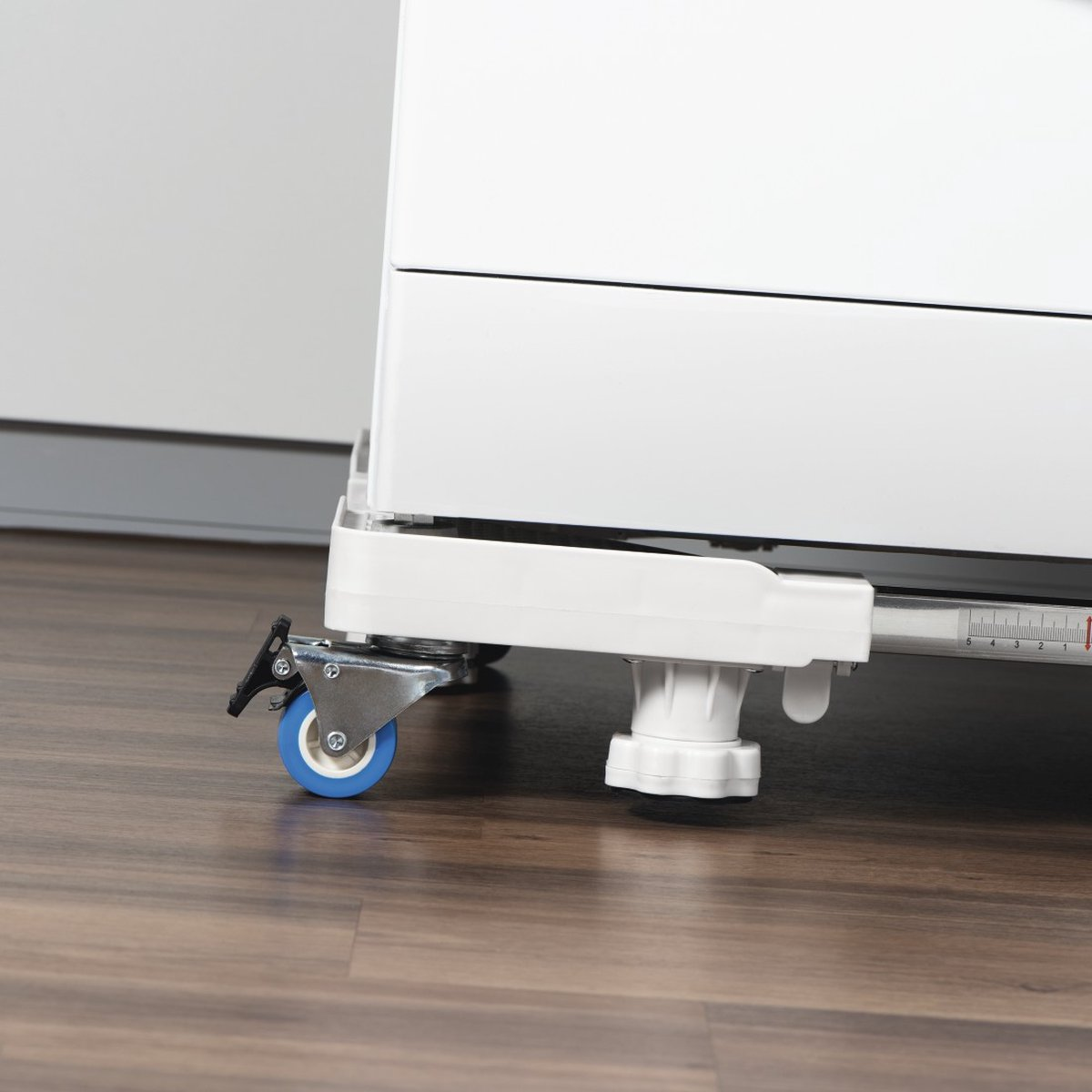 A white machine sits on an adjustable base with wheels.