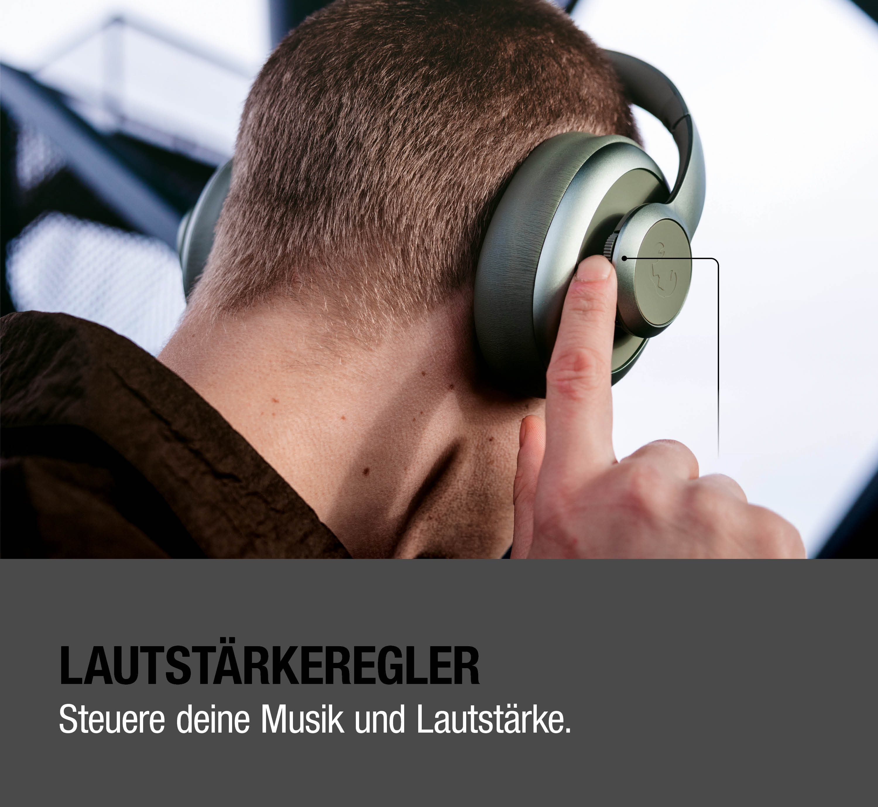 Mann mit Kopfhörern, der einen Lautstärkeregler bedient.