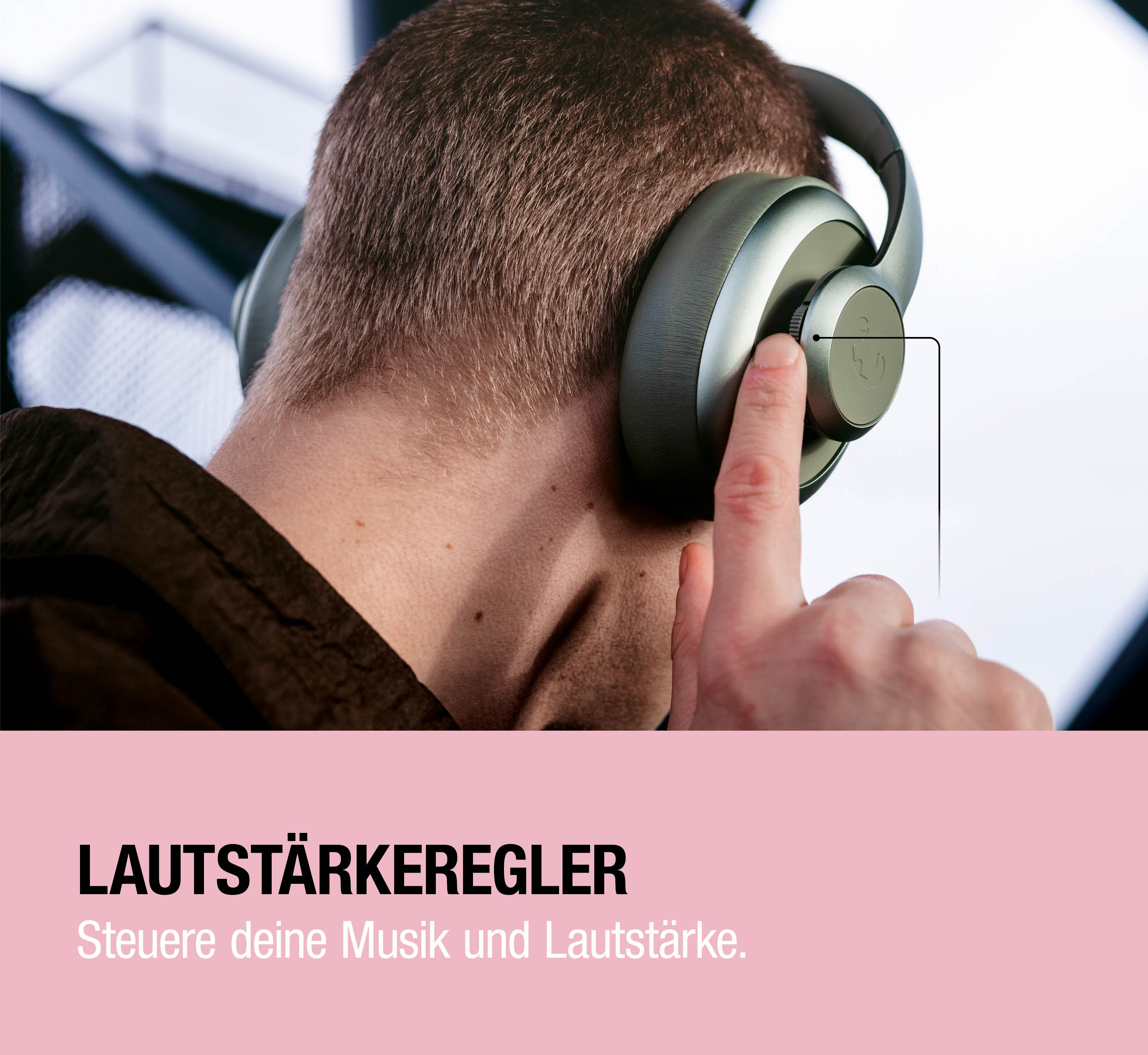 Ein Mann trägt Kopfhörer und bedient den Lautstärkeregler mit dem Finger.