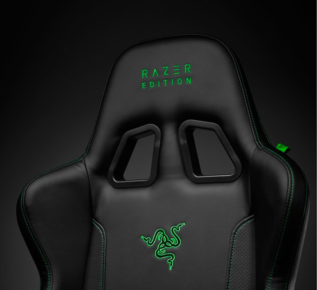 Zwarte gamestoel met groene stiksels en logo.