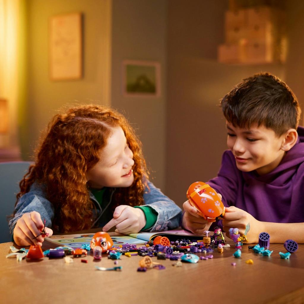 İki çocuk masada renkli Lego tuğlalarıyla inşaat yapıyor.