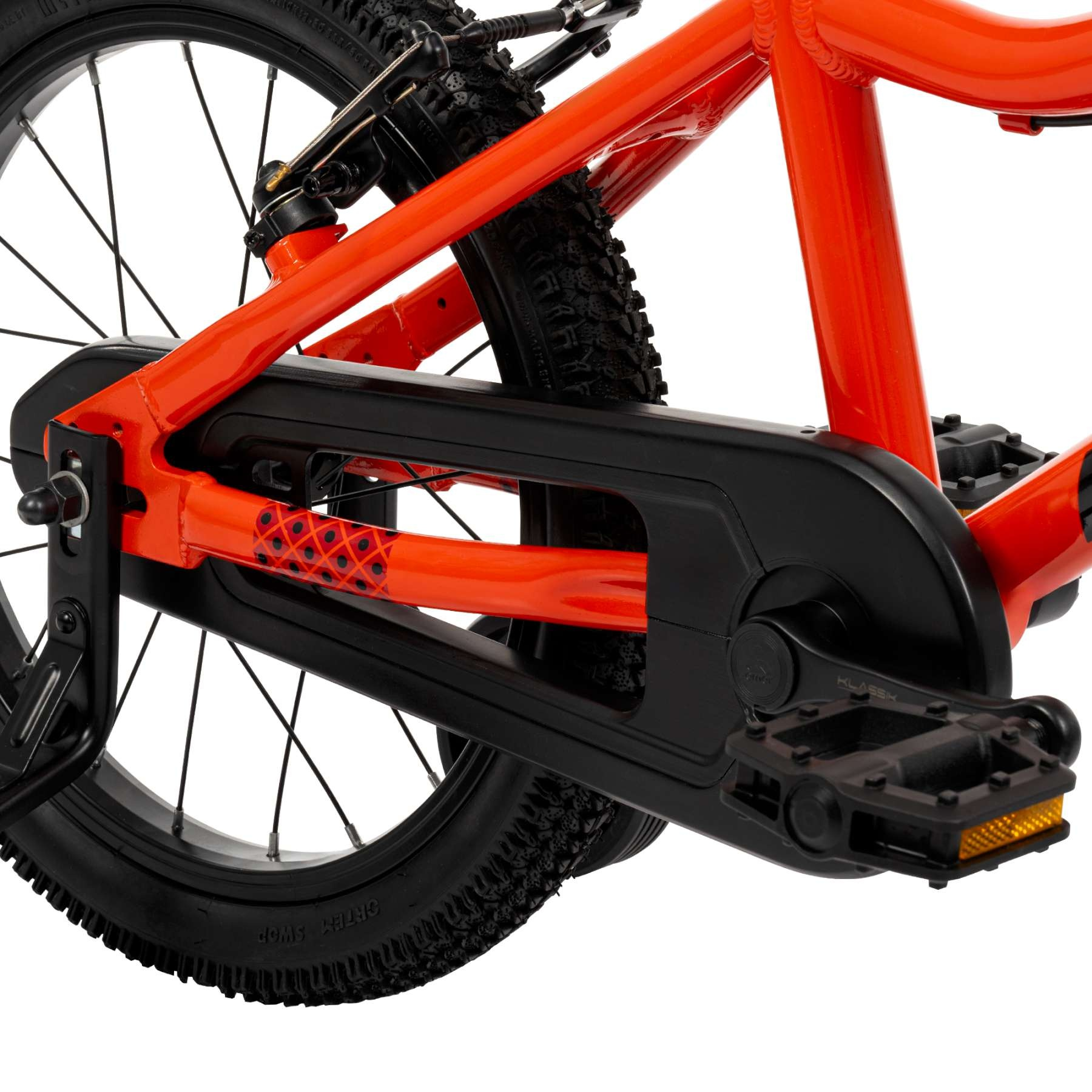 Nahaufnahme der Rückseite eines orangefarbenen Fahrrads mit schwarzer Kette und Pedalen.