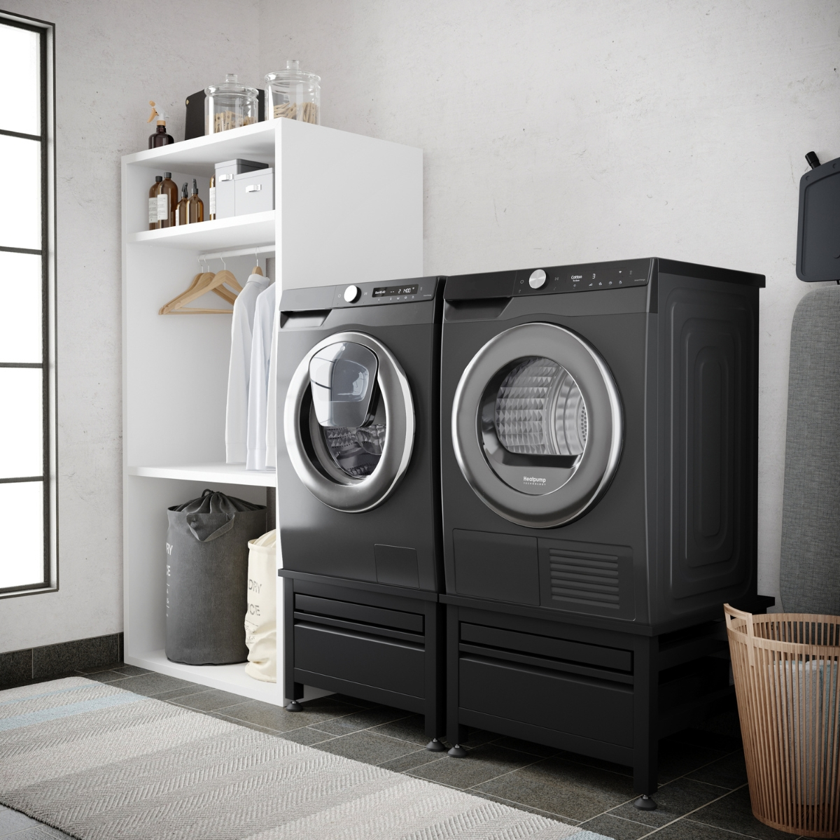 Black washer and dryer side-by-side on pedestals, with a shelf unit beside them.