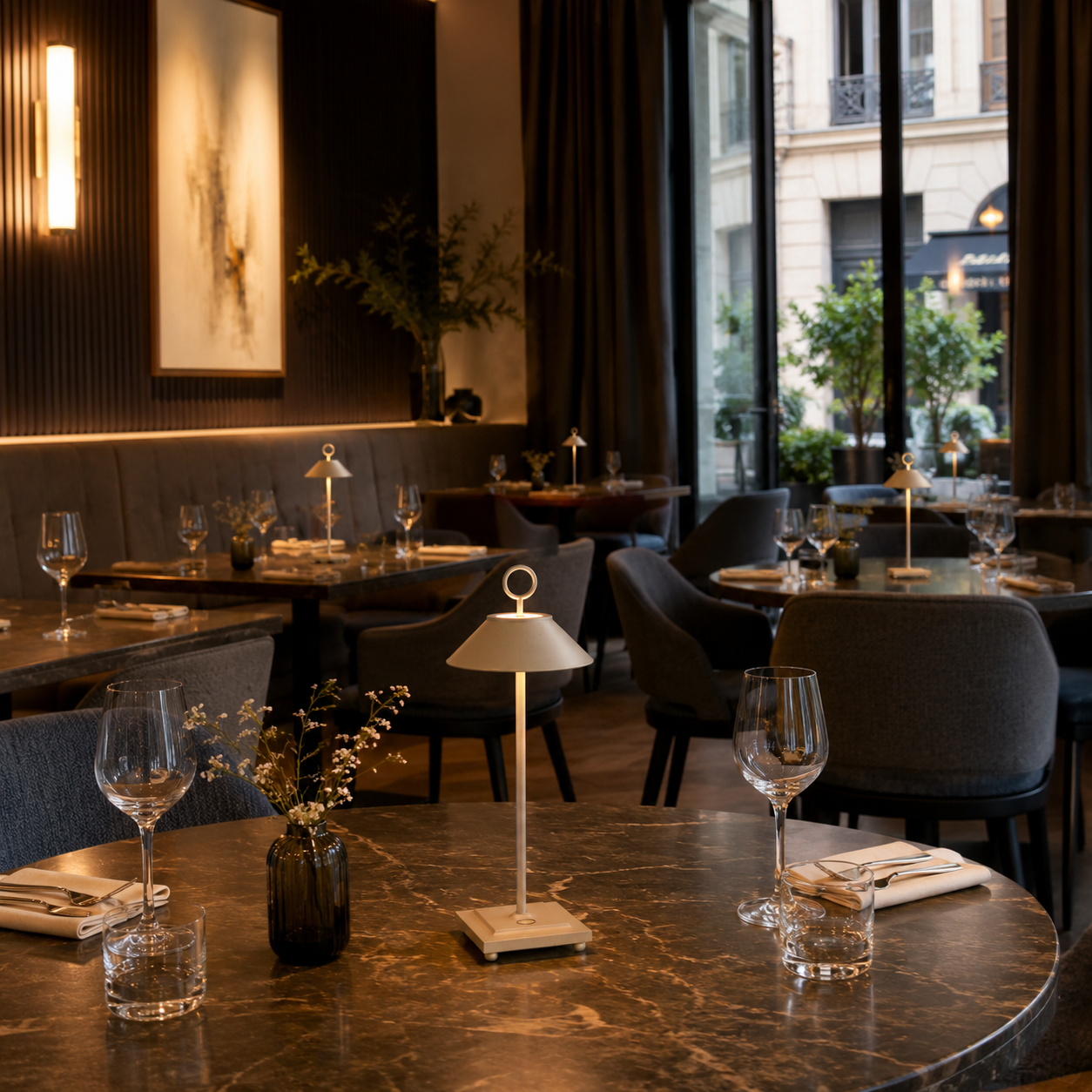 Elegantes Restaurantinterieur mit Marmortischen, Stühlen und stimmungsvoller Beleuchtung.