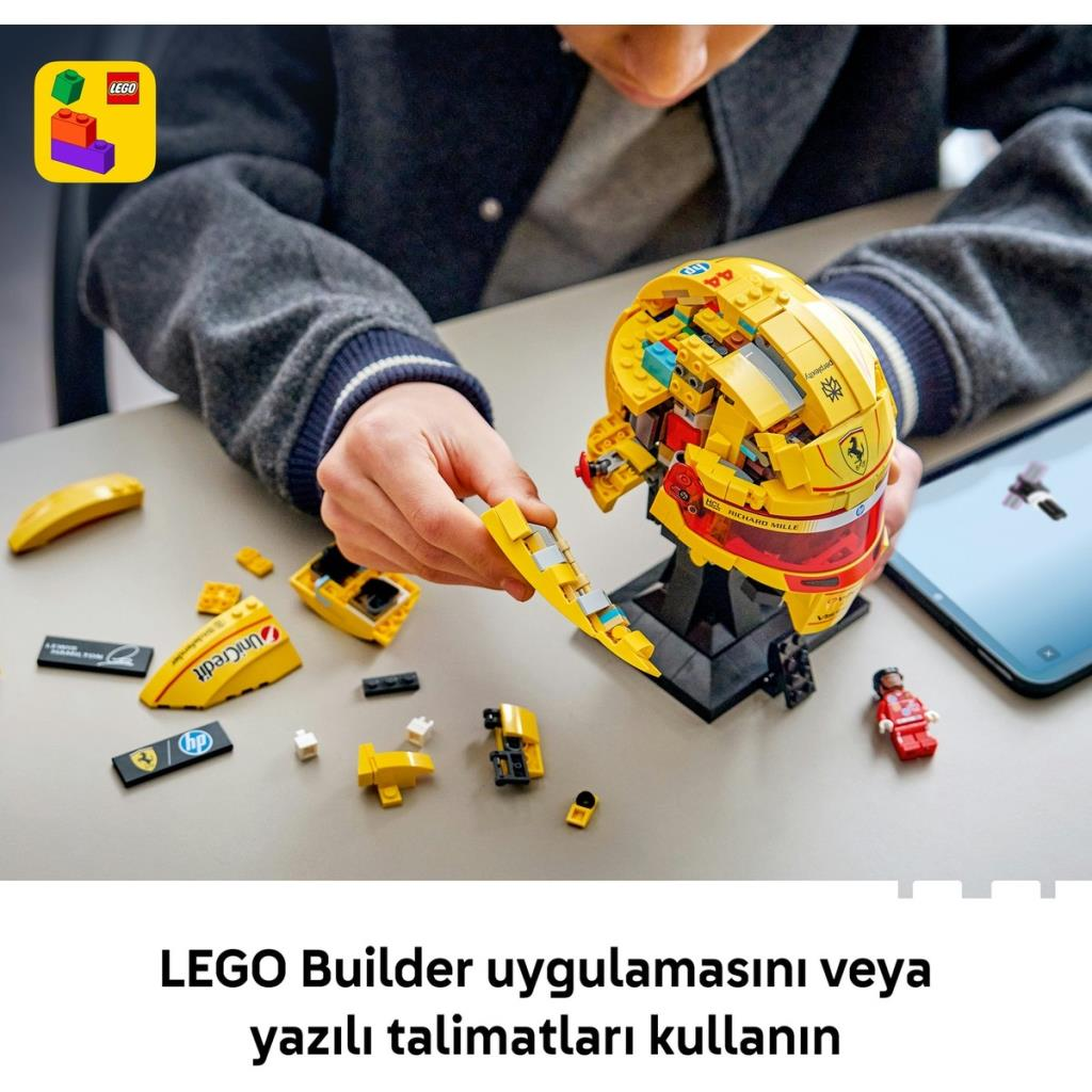 Çocuk sarı LEGO kaskı yapıyor, parçalar masada.