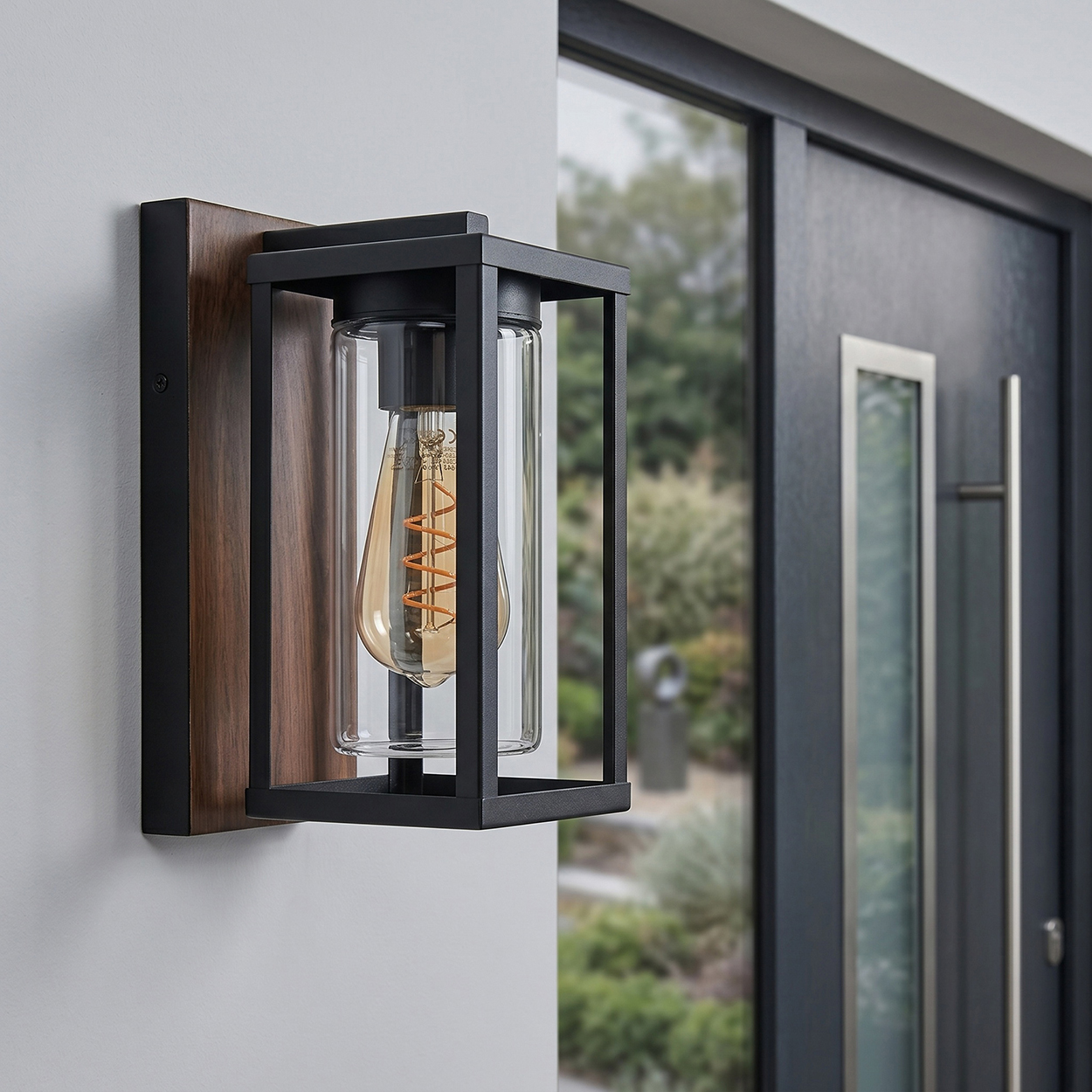 Moderner Wandleuchter mit Holzrückwand, schwarzem Metallrahmen und Glaszylinder.