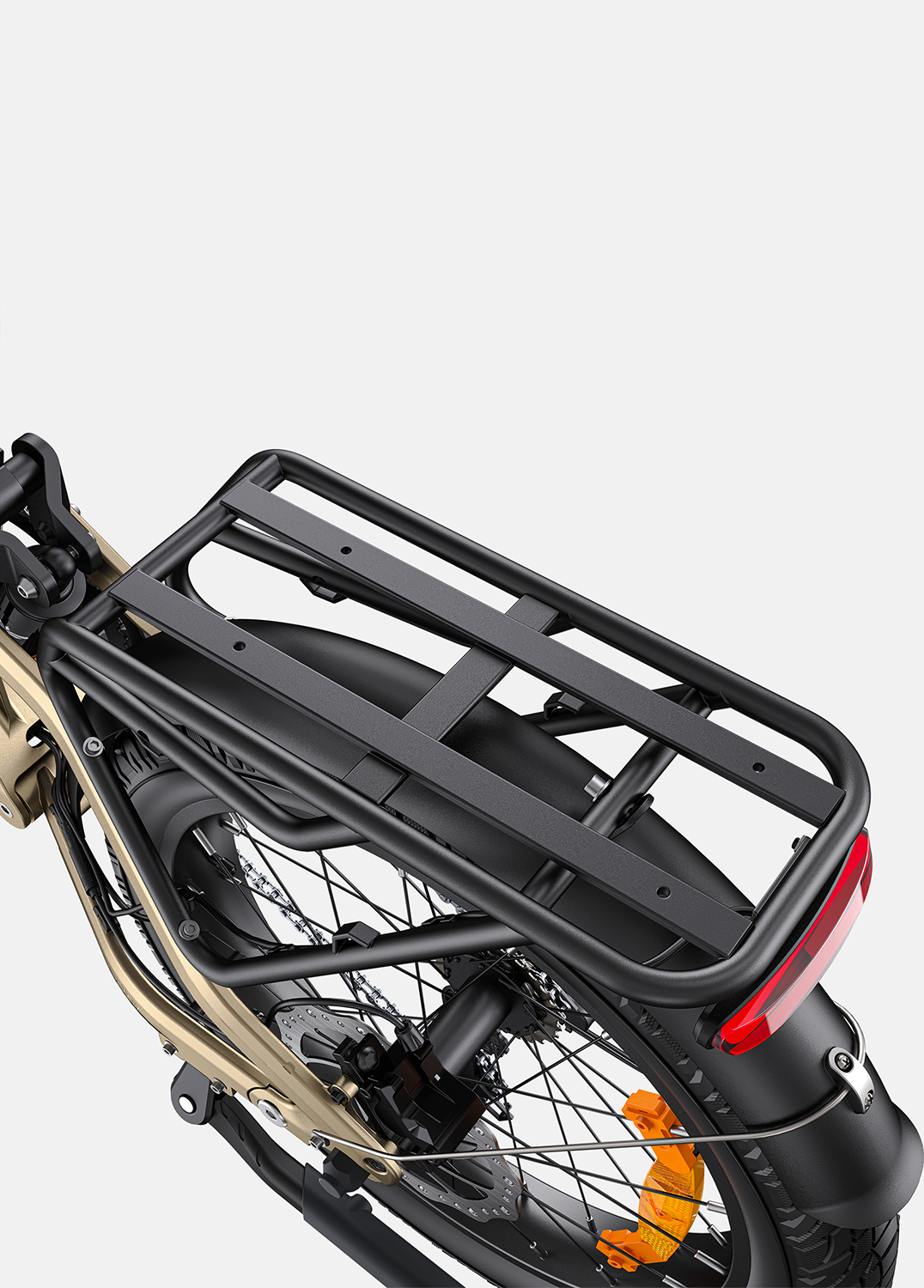 Primer plano de un cuadro de bicicleta dorado con portaequipajes negro, luz trasera y rueda de radios.