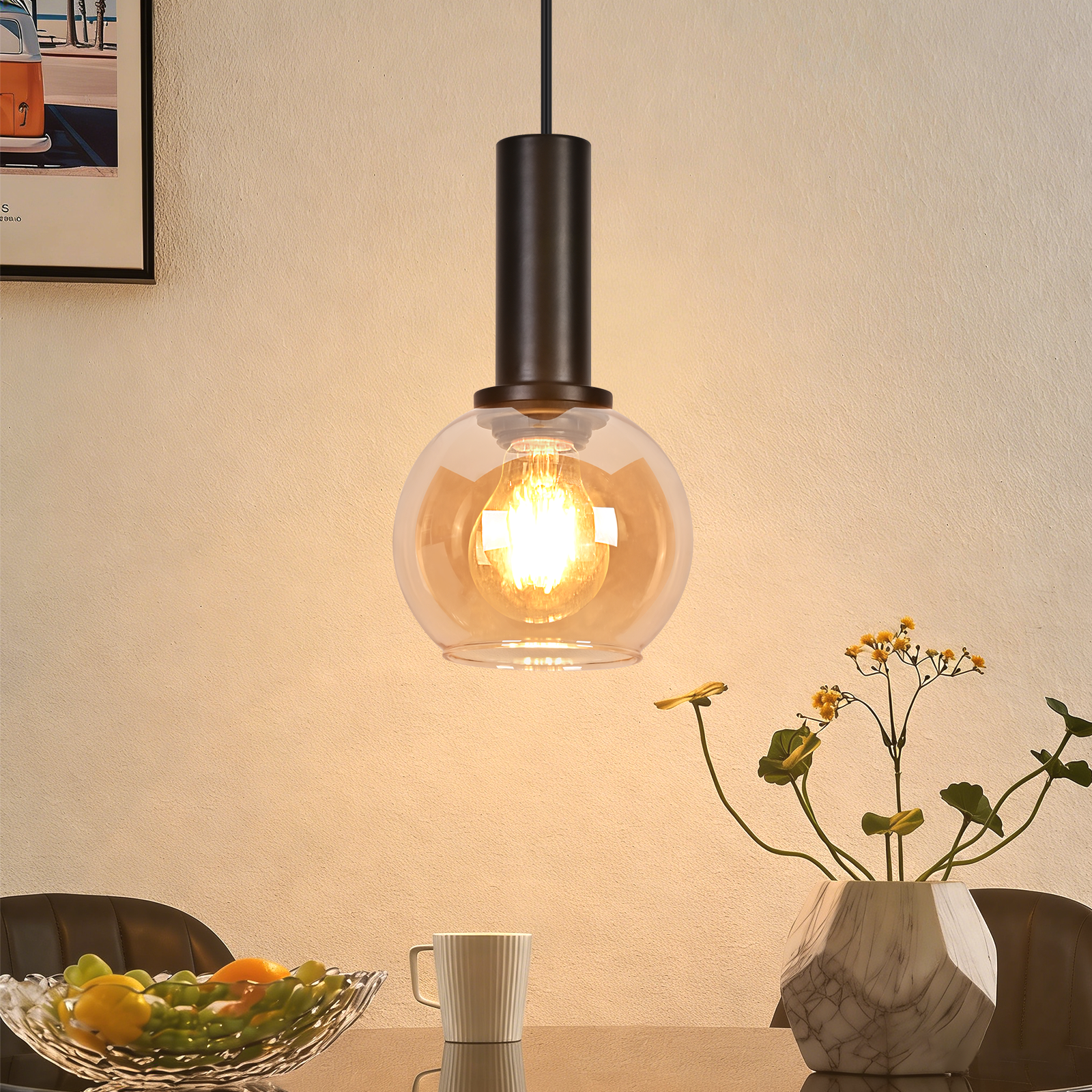 Lampa wisząca ze szklaną kulą i żarówką nad stołem z miską owoców.