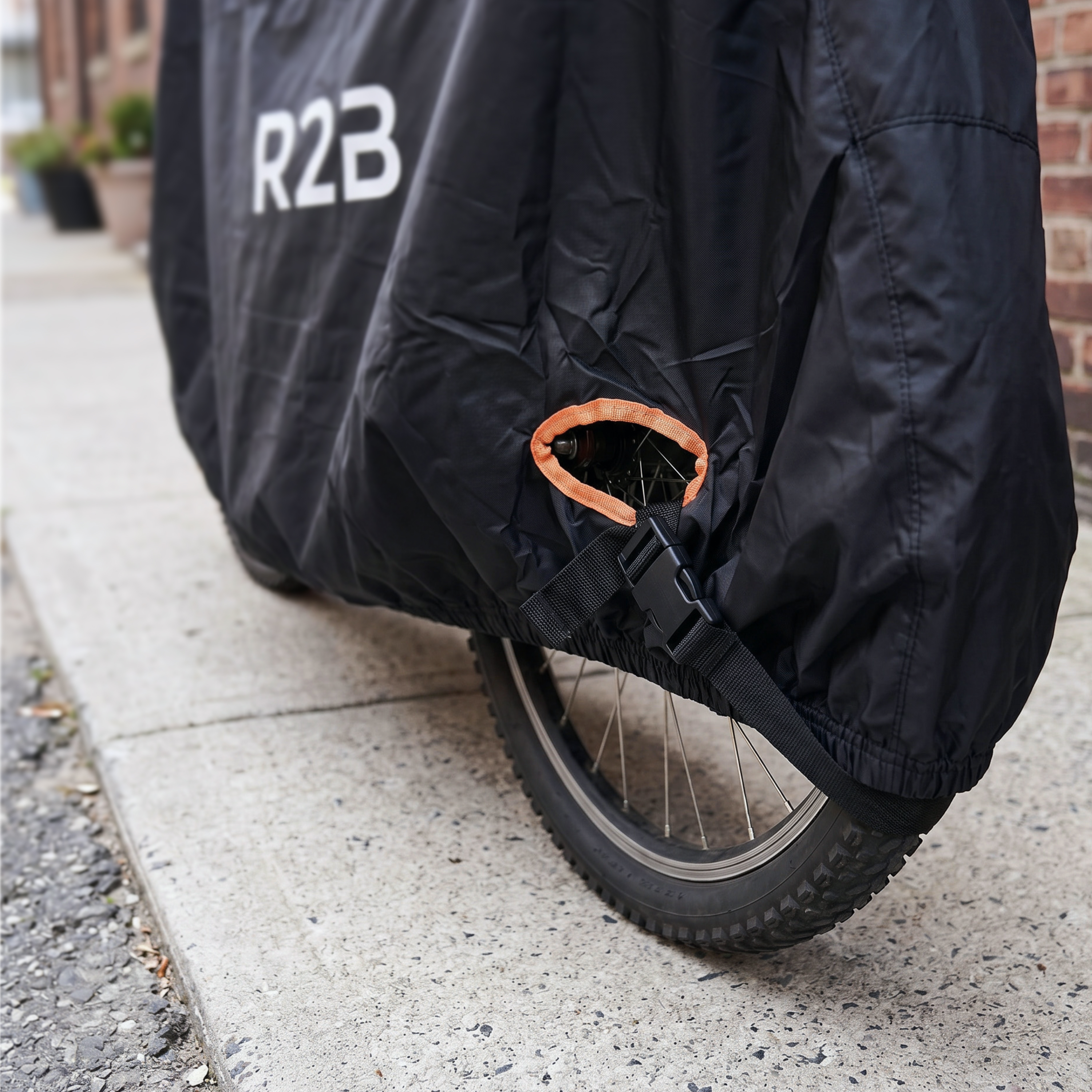 Black bicycle cover with orange trim, wheel, and buckle.