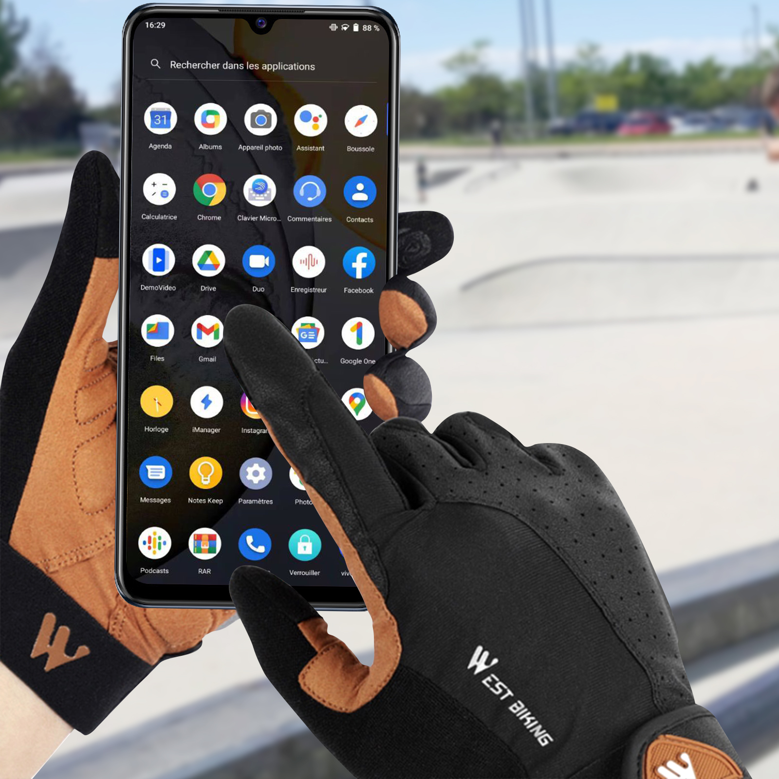 Mani guantate usano uno smartphone con molte icone di app davanti a uno skate park.