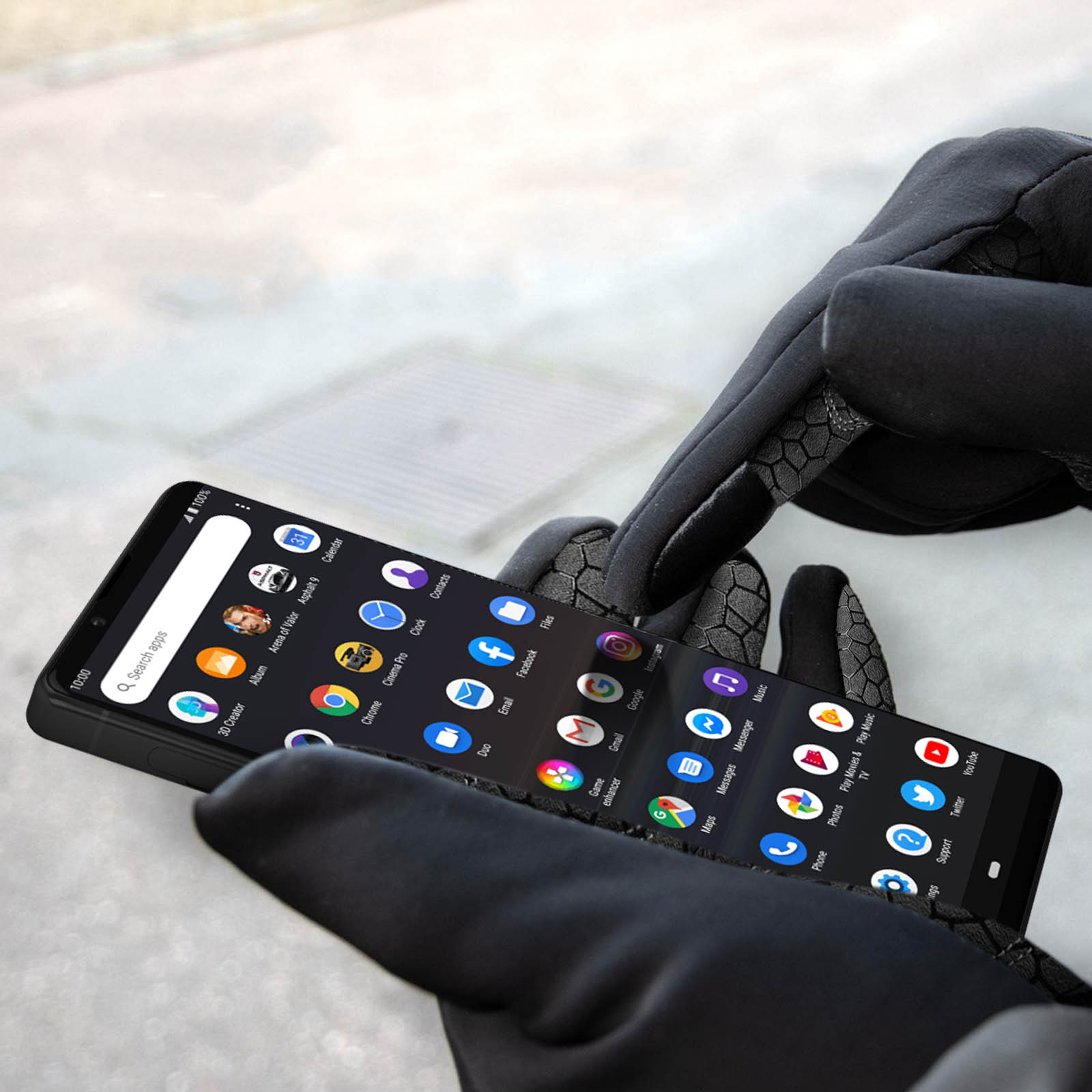 Mani con guanti neri usano uno smartphone con molte icone di app.