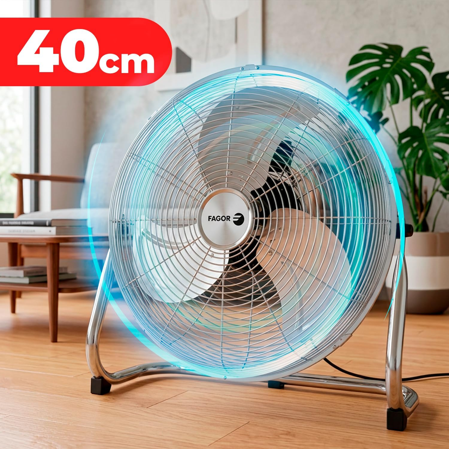 Un ventilador plateado de 40cm sobre suelo de madera con efectos de luz azul.