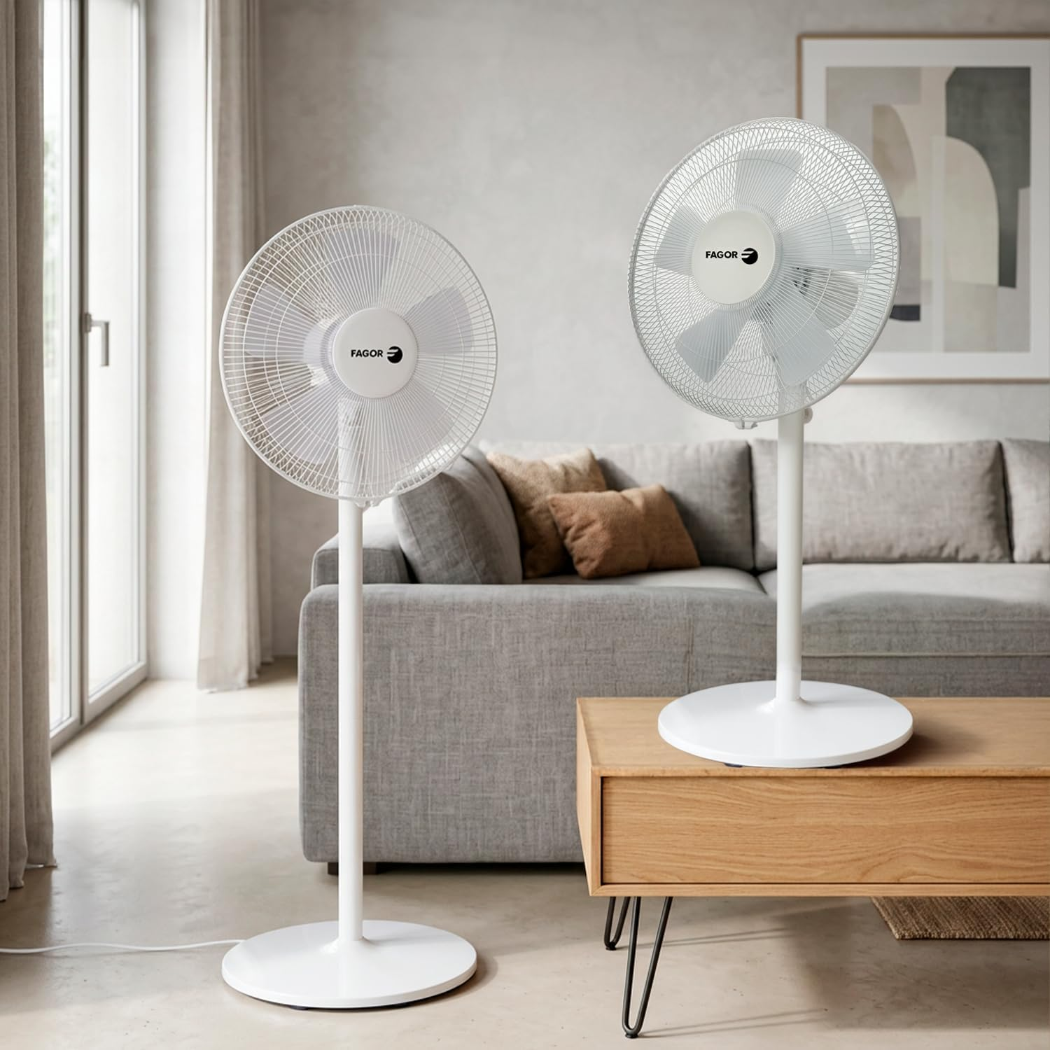 Dos ventiladores blancos de pie están en una sala de estar junto a un sofá.