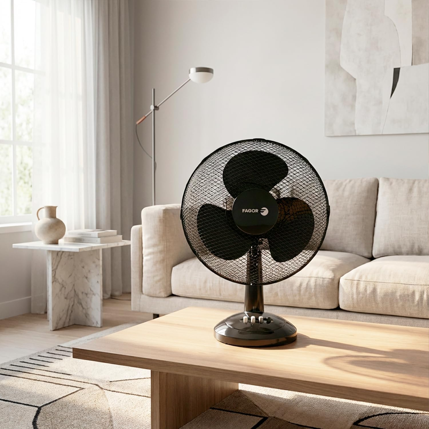 Un ventilador de mesa negro está sobre una mesa de madera en una sala.