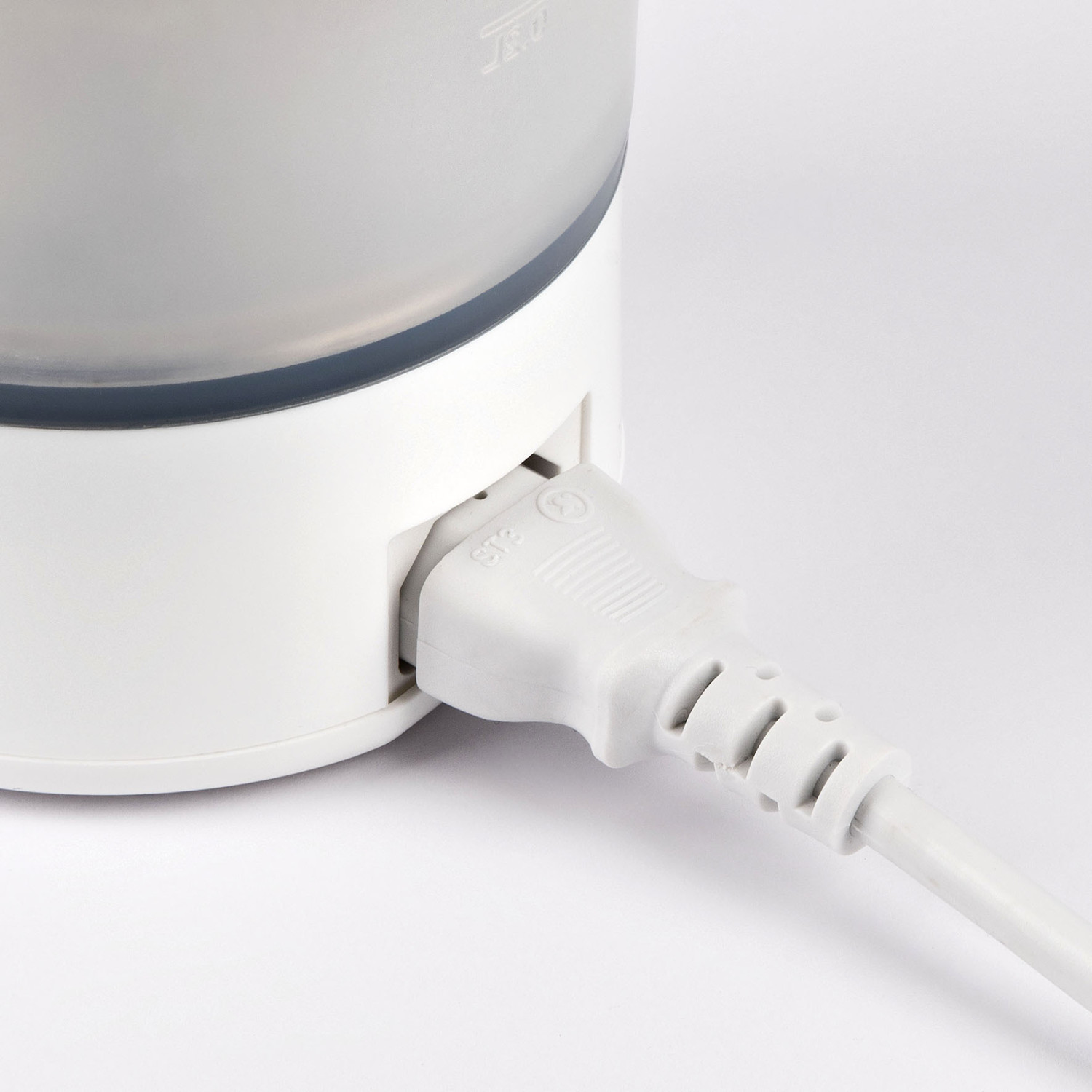 Ein weißer Stecker ist in ein weißes Gerät eingesteckt.