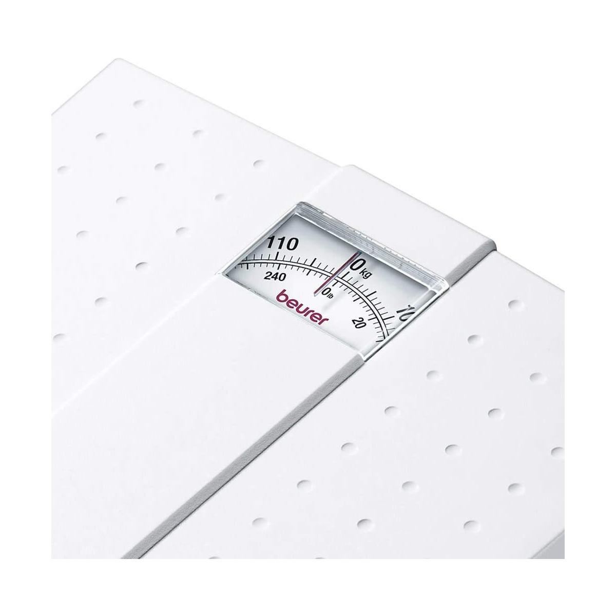 Weiße Personenwaage mit analoger Anzeige, die 110 kg anzeigt.