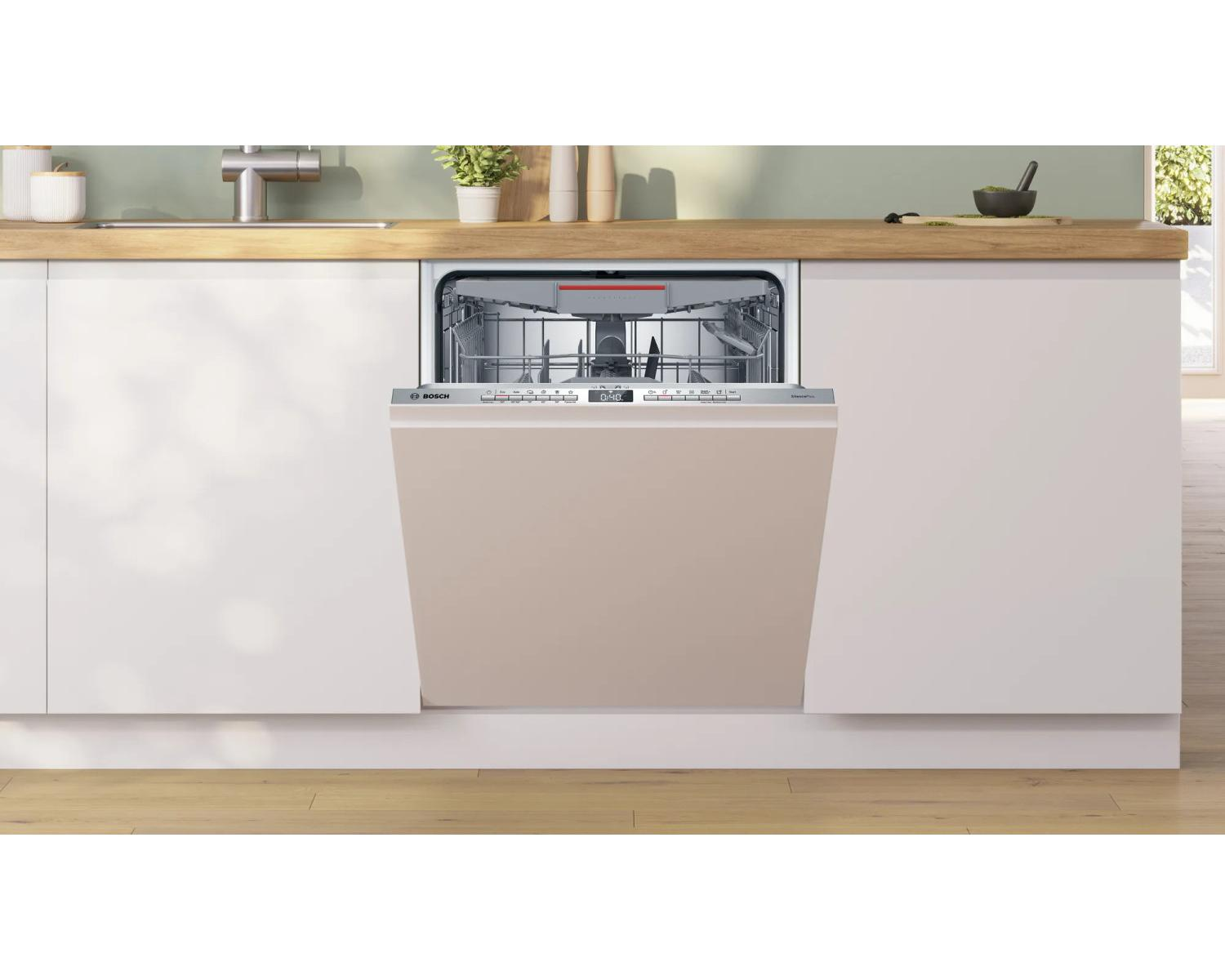 Una lavastoviglie aperta con interno argento e frontale beige in una cucina moderna.
