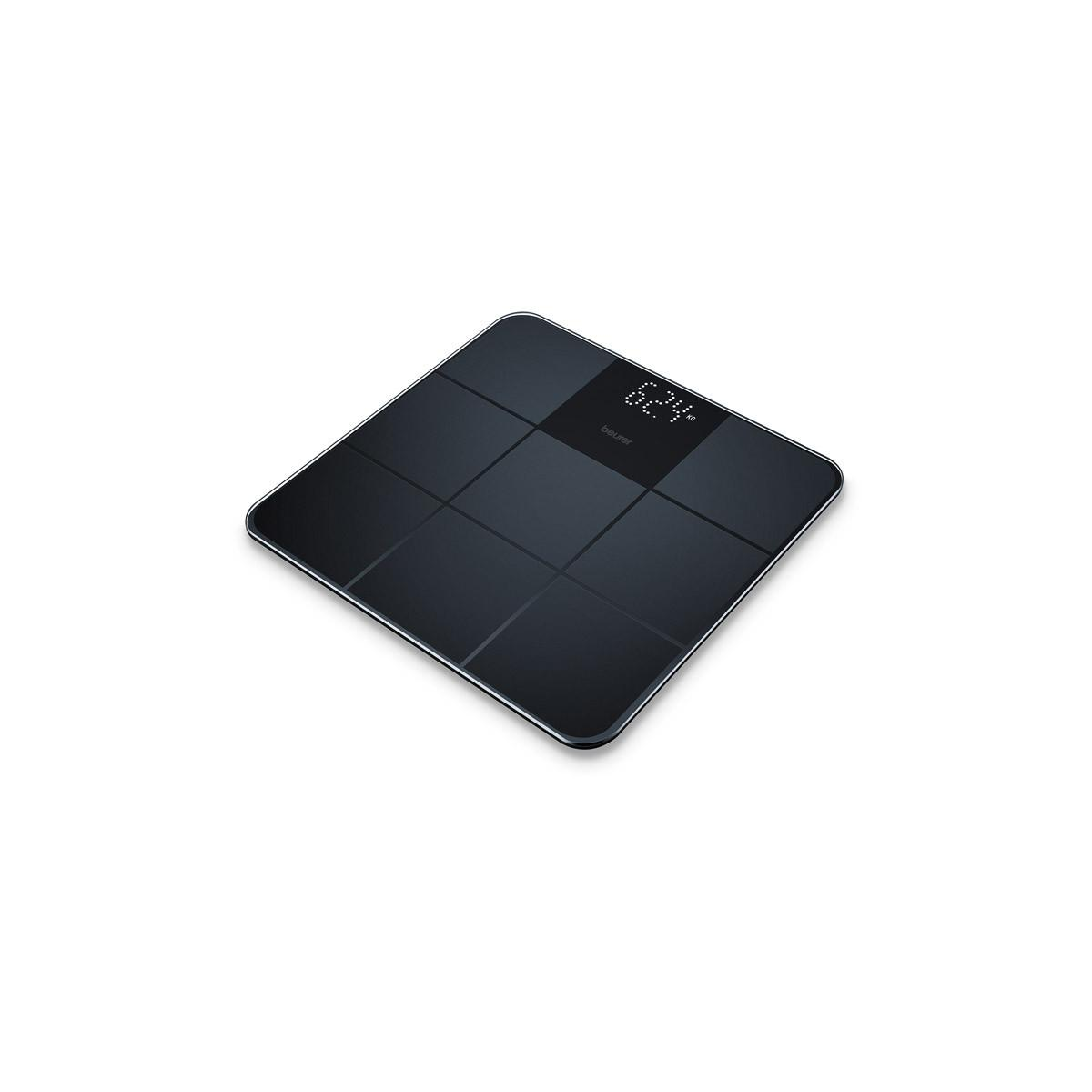 Una báscula corporal digital negra con pantalla que muestra 62,4 kg.