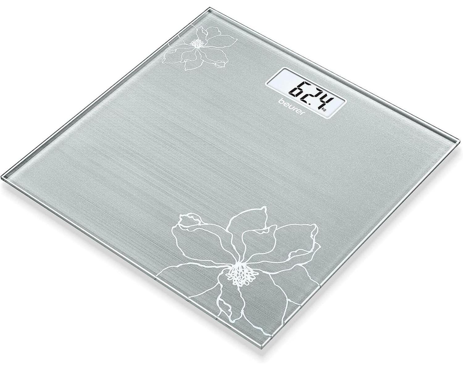 Una báscula de vidrio que muestra 62,4 kg con un patrón floral.