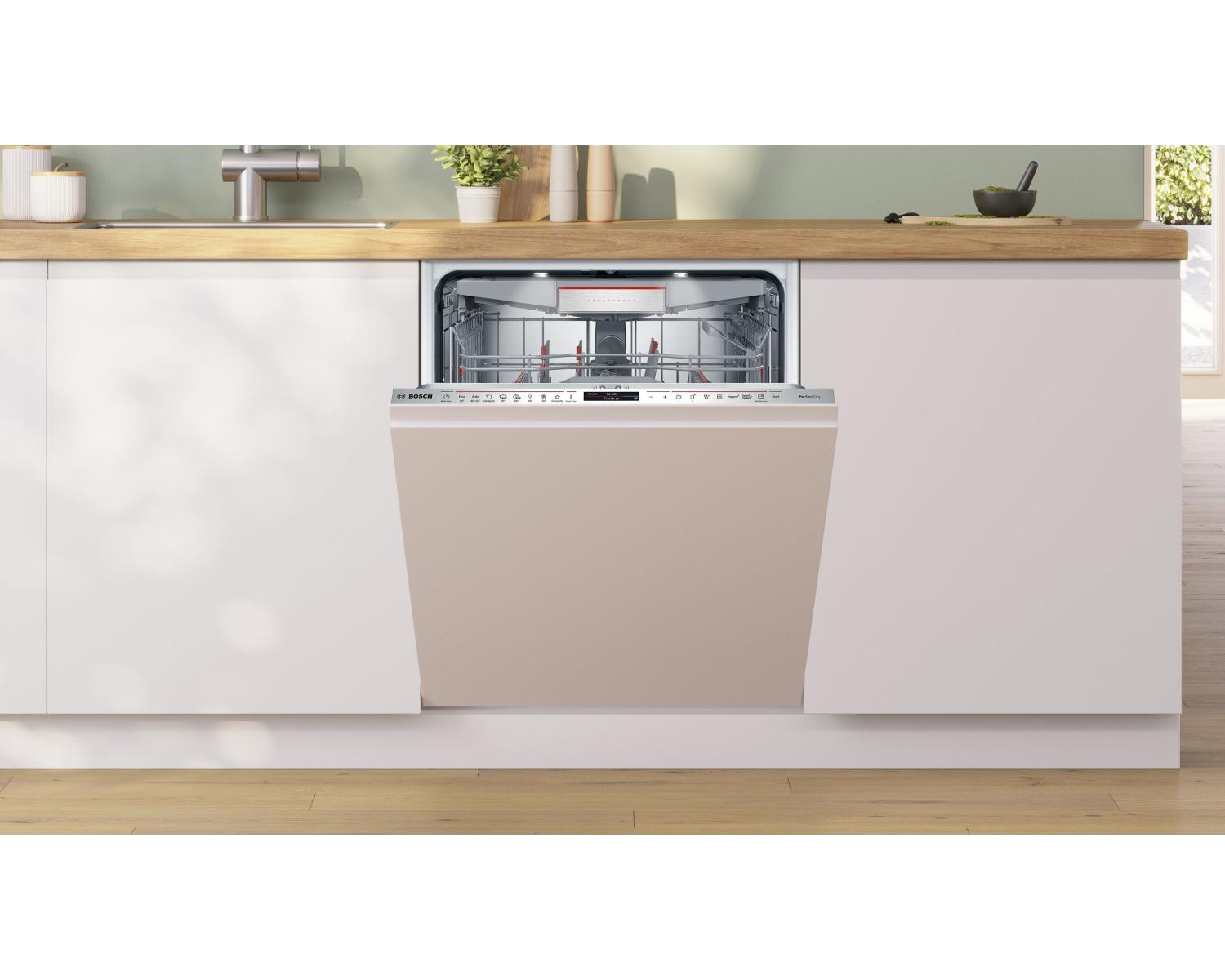 Una lavastoviglie beige con porta aperta in una cucina moderna.