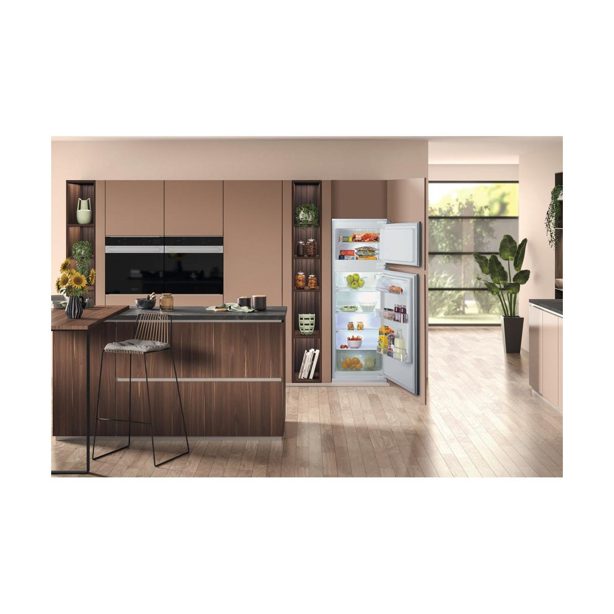Cucina moderna con porte del frigorifero aperte, forni da incasso, pavimenti in legno e piante.