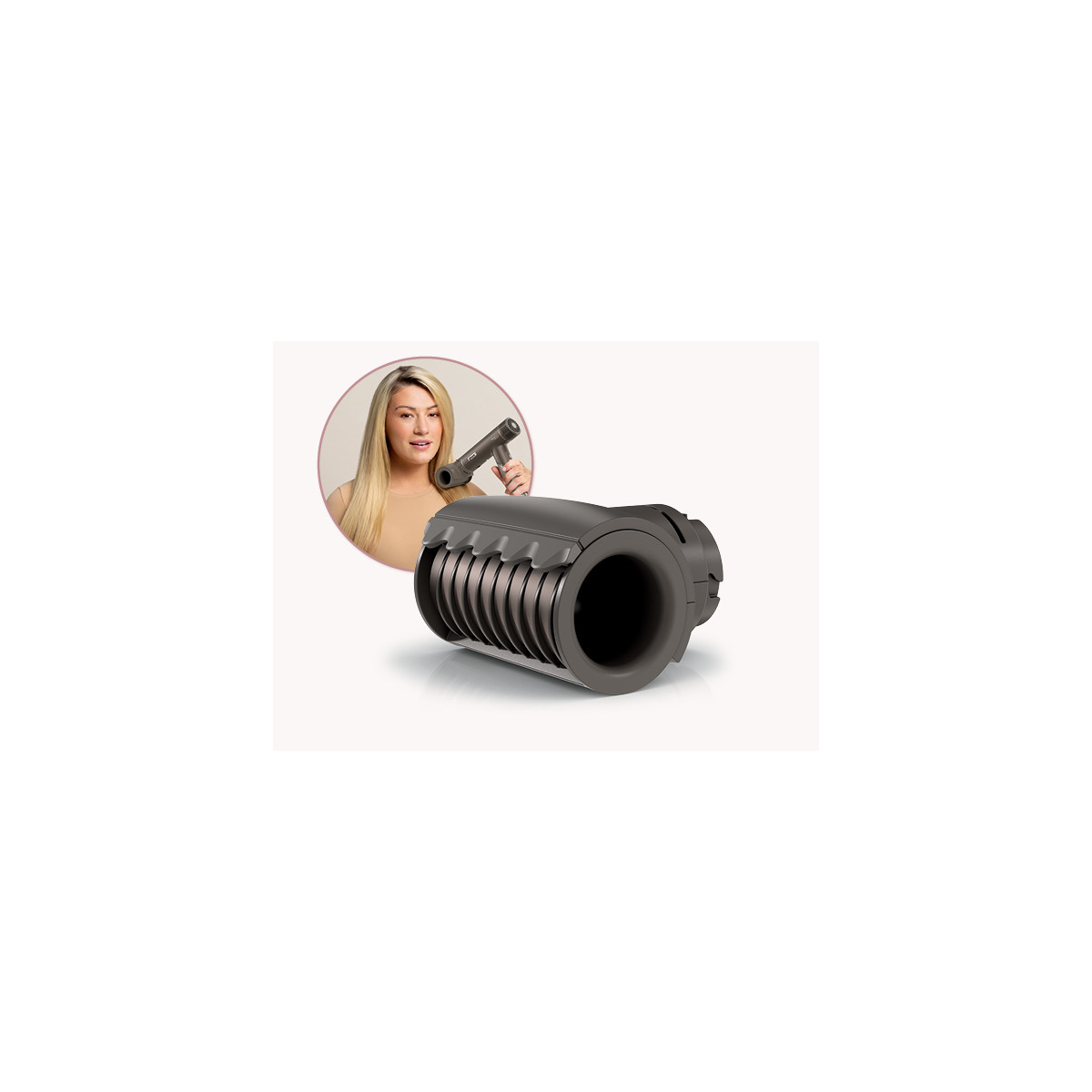 A woman with long blonde hair holds a dark hair dryer. Close up of attachment.