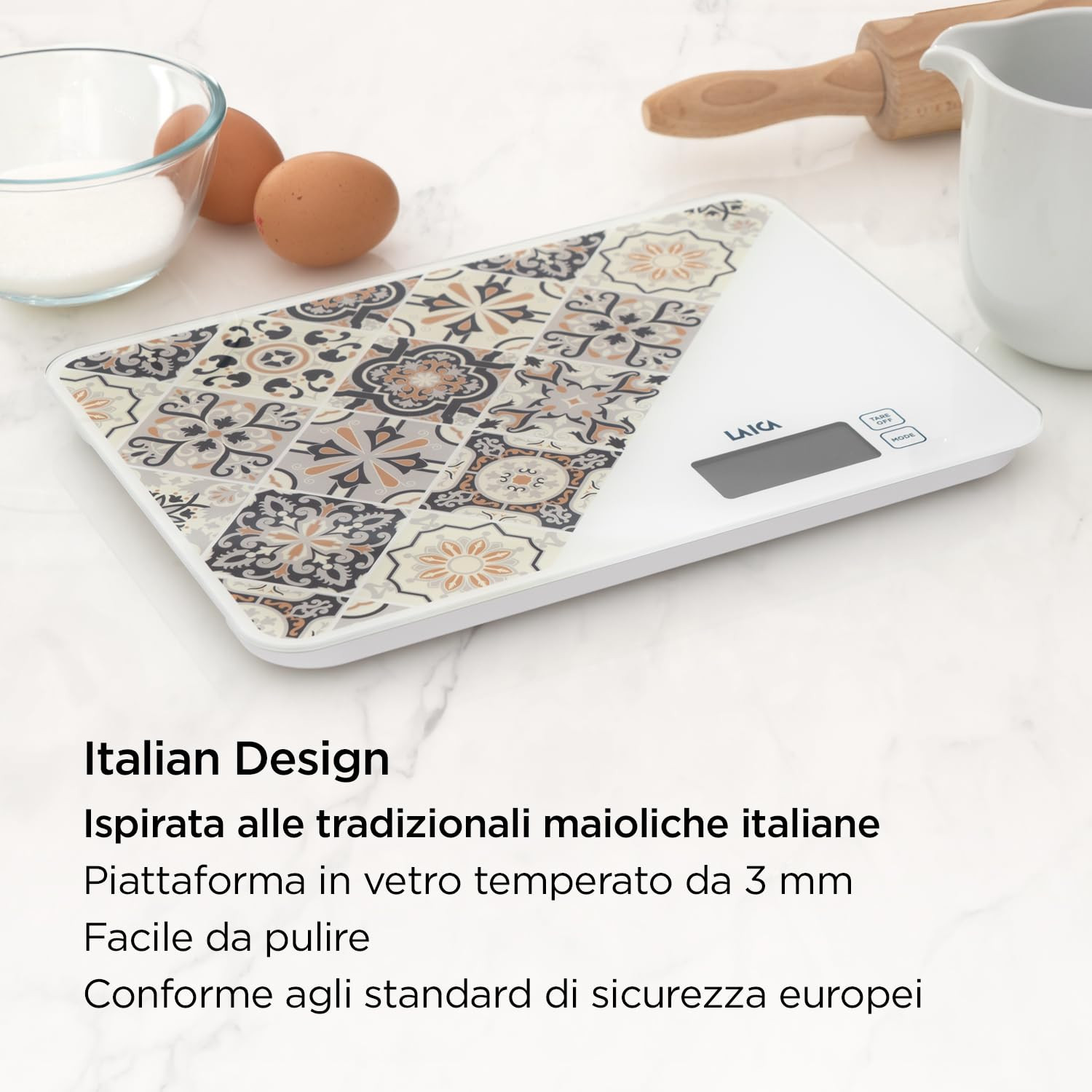 Eine digitale Küchenwaage mit italienischem Fliesenmuster, Eiern und einer Zuckerschale.