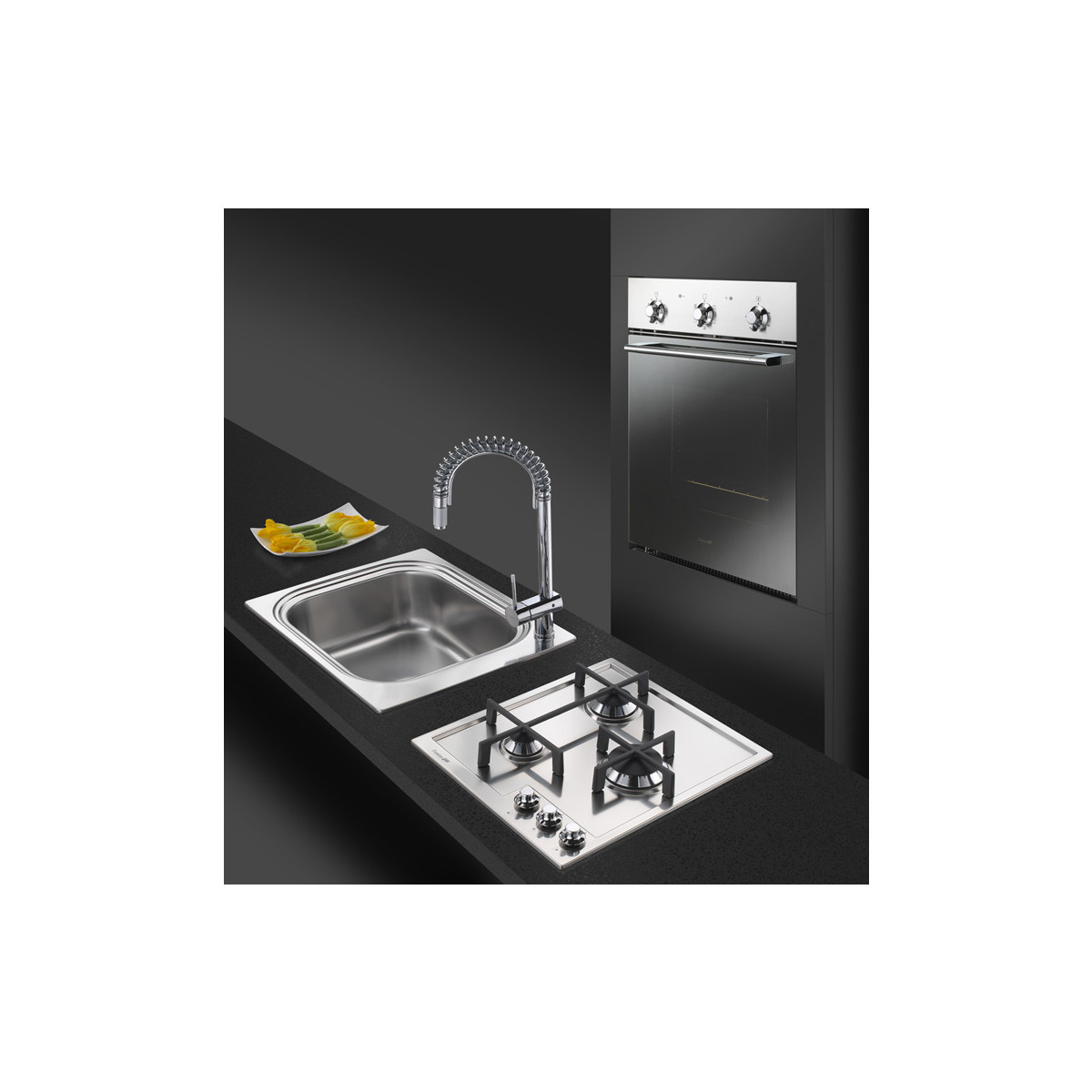 Lavello in acciaio inox con rubinetto, piano cottura a gas e forno da incasso.