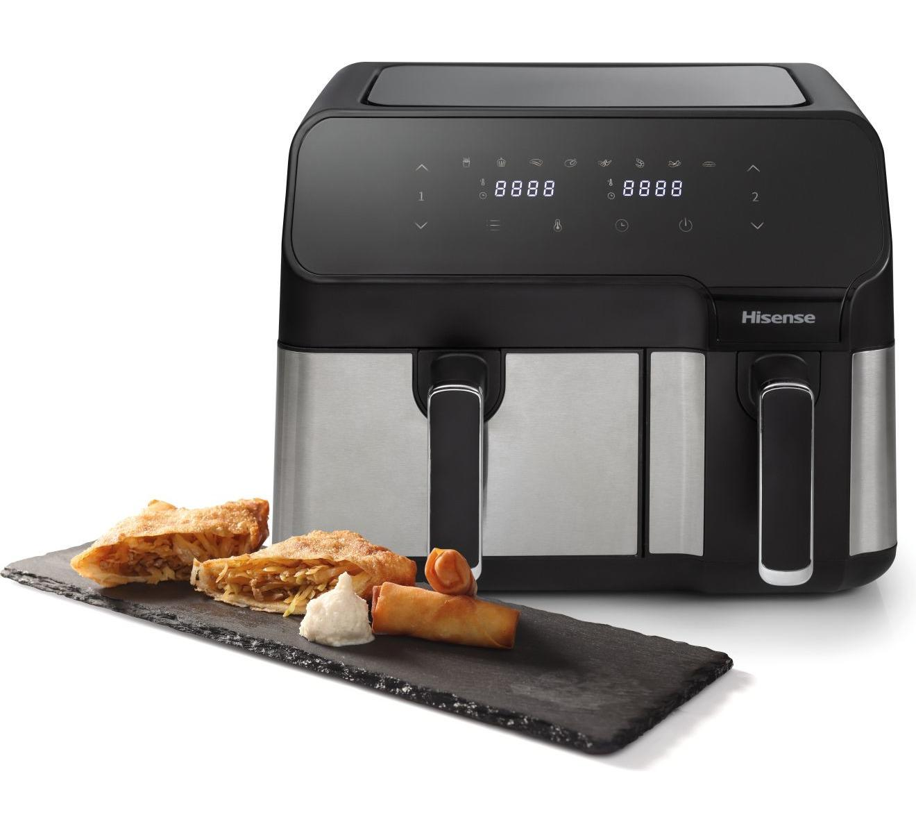Een Hisense heteluchtfriteuse met dubbele mand met snacks op een leisteen dienblad ervoor.