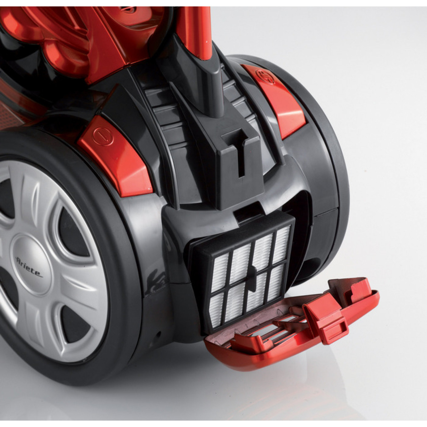 Red and black vacuum cleaner with a silver wheel and an open filter compartment.