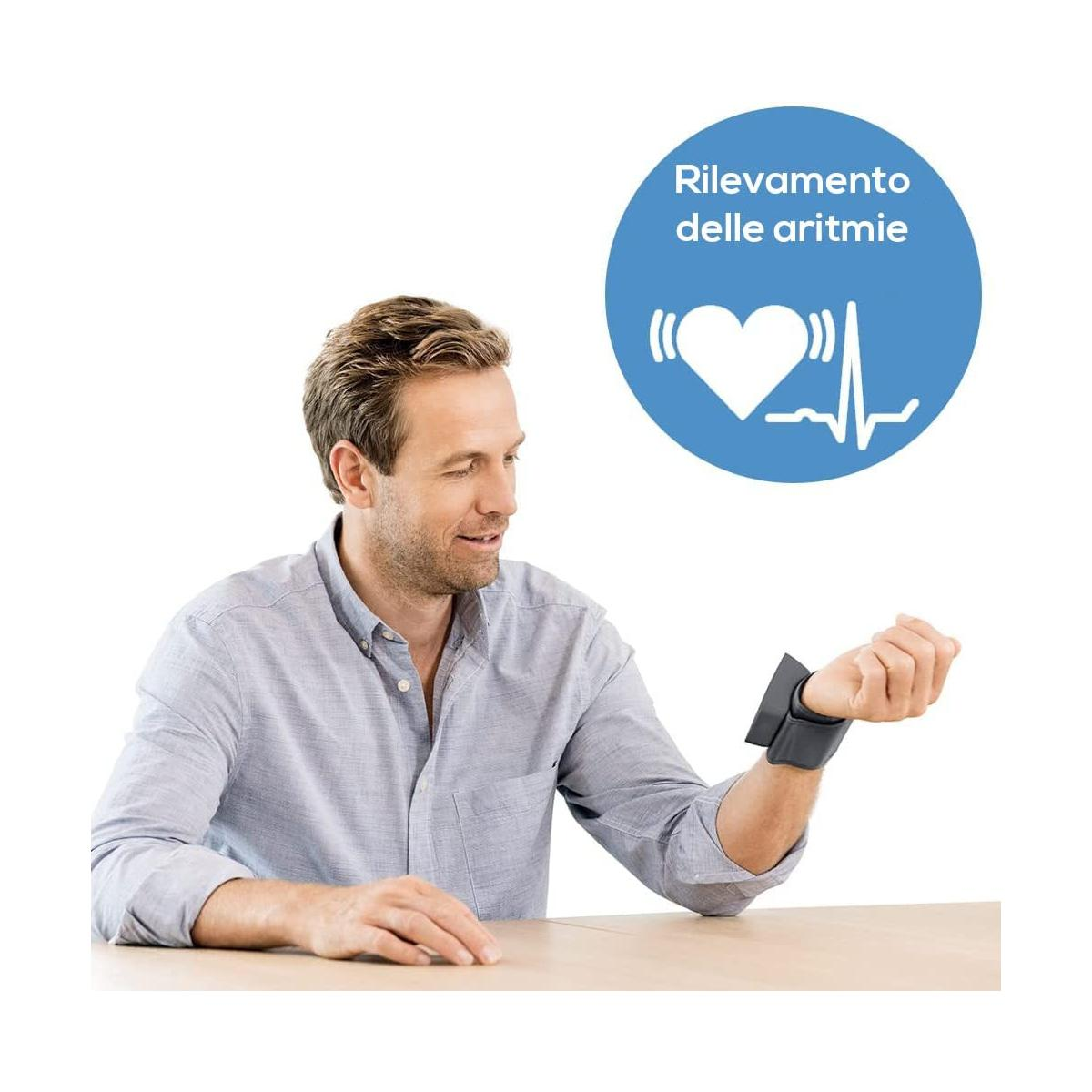 Mann mit Armmanschette sitzt am Tisch, Herzsymbol mit EKG im Kreis.