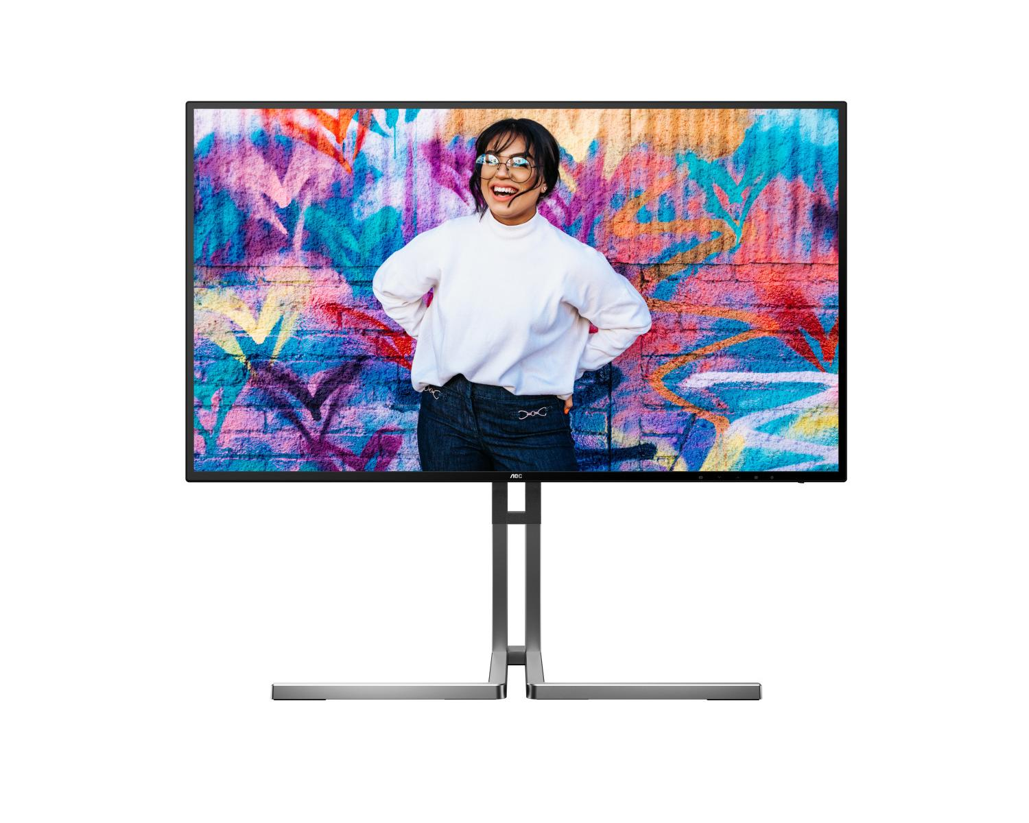Een lachende vrouw in een witte trui voor een kleurrijke graffiti muur op een monitor.