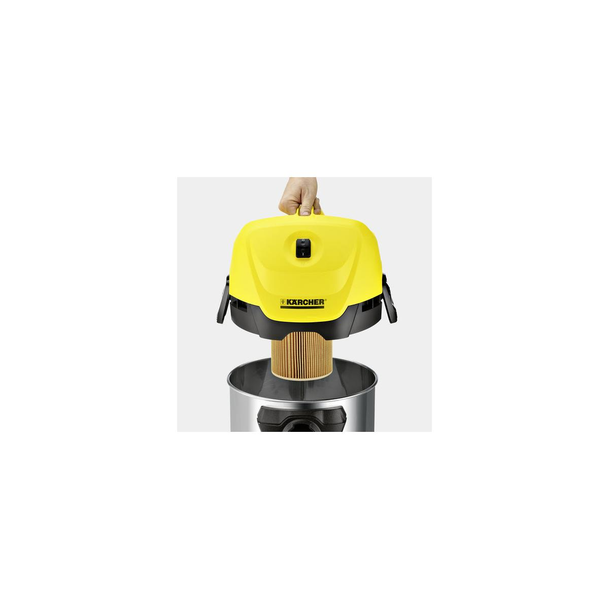 Una persona tiene la testa gialla dell'aspirapolvere Karcher con filtro sopra un contenitore di metallo.